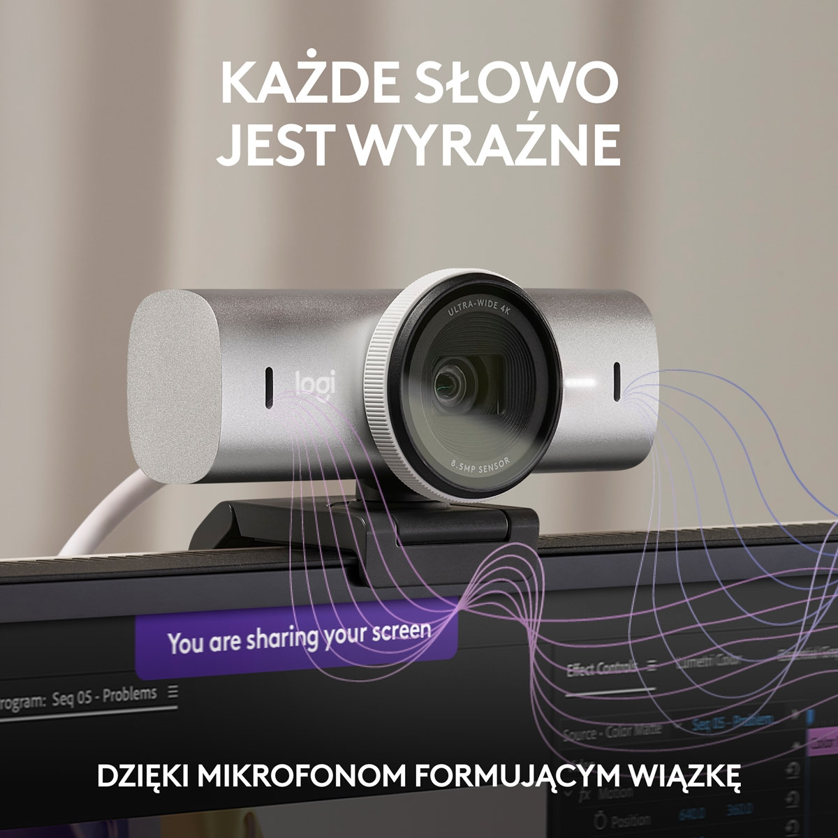 Srebrna kamera internetowa na monitorze, tekst u góry, fioletowe linie.