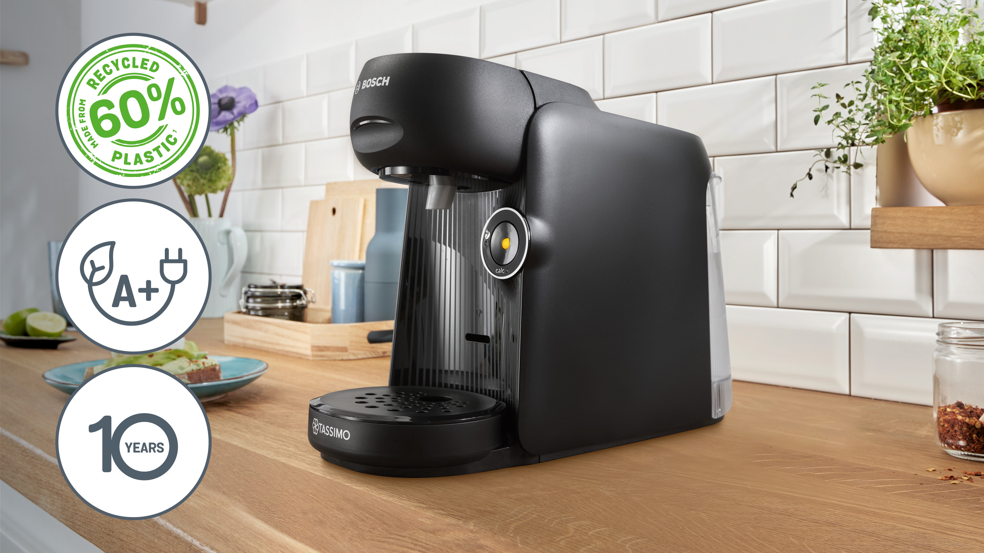 Schwarze Bosch Tassimo Kaffeemaschine auf Holzoberfläche, mit Logos für Funktionen.