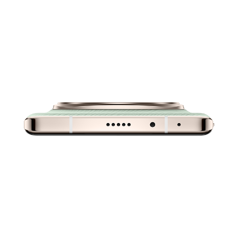 Primer plano de un teléfono verde claro con marco dorado, mostrando la parte inferior con puertos, fondo negro.