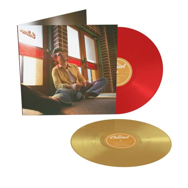 Eine rote und eine goldene Schallplatte auf einem Cover, mit einem Mann, der sitzt.