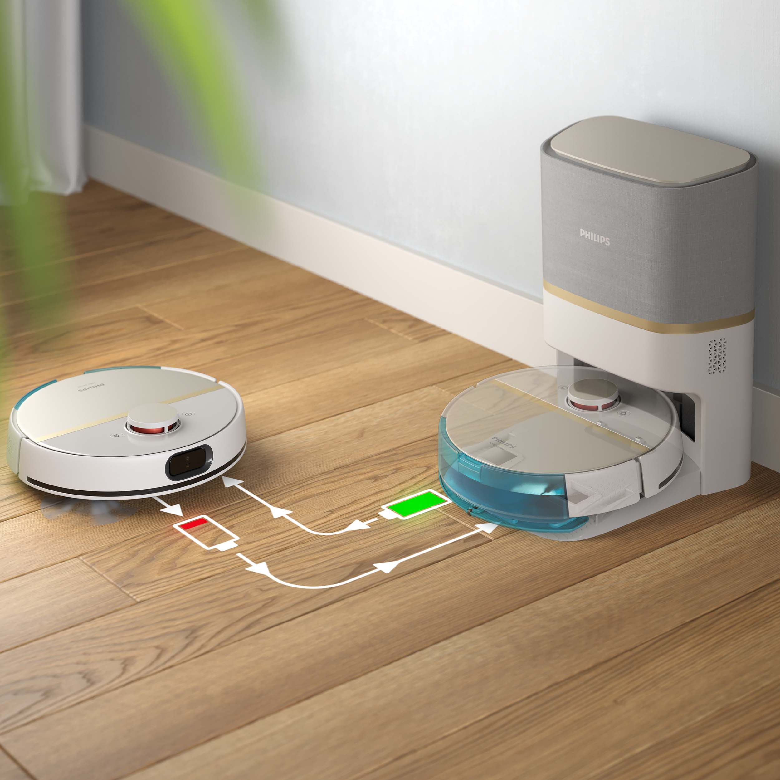 Odkurzacz robot ładuje się. Jeden jest na podłodze. Drugi w stacji ładującej.
