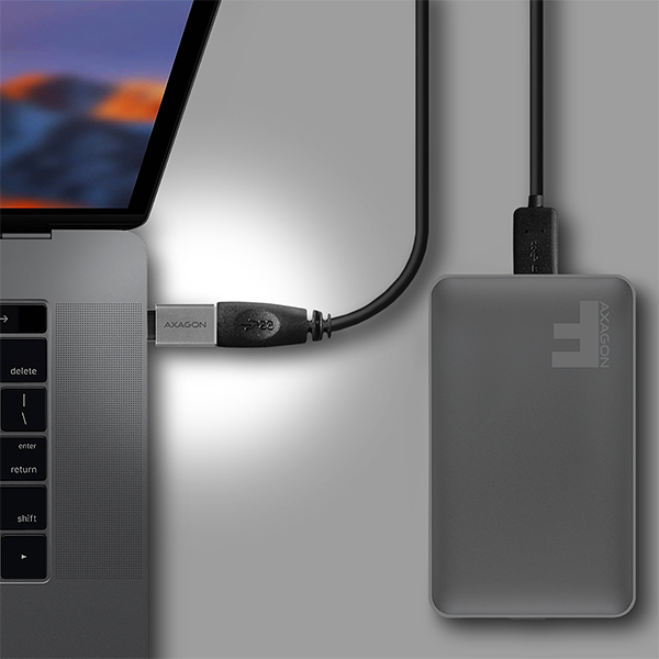 Egy laptop, amely egy USB-kábelen keresztül egy merevlemezhez van csatlakoztatva. A merevlemez szürke.