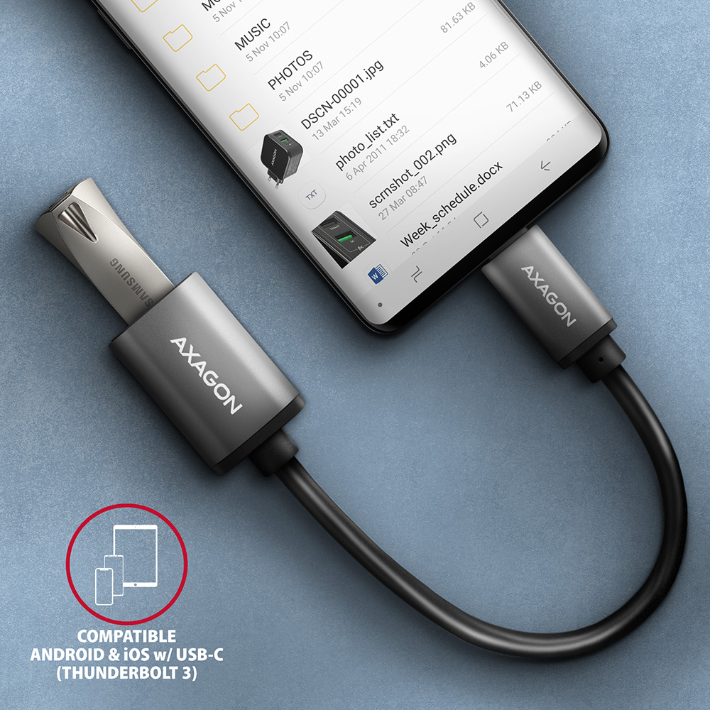 Telefon egy ezüst USB-C adapterhez csatlakoztatva. Az adapter a telefonhoz van csatlakoztatva.