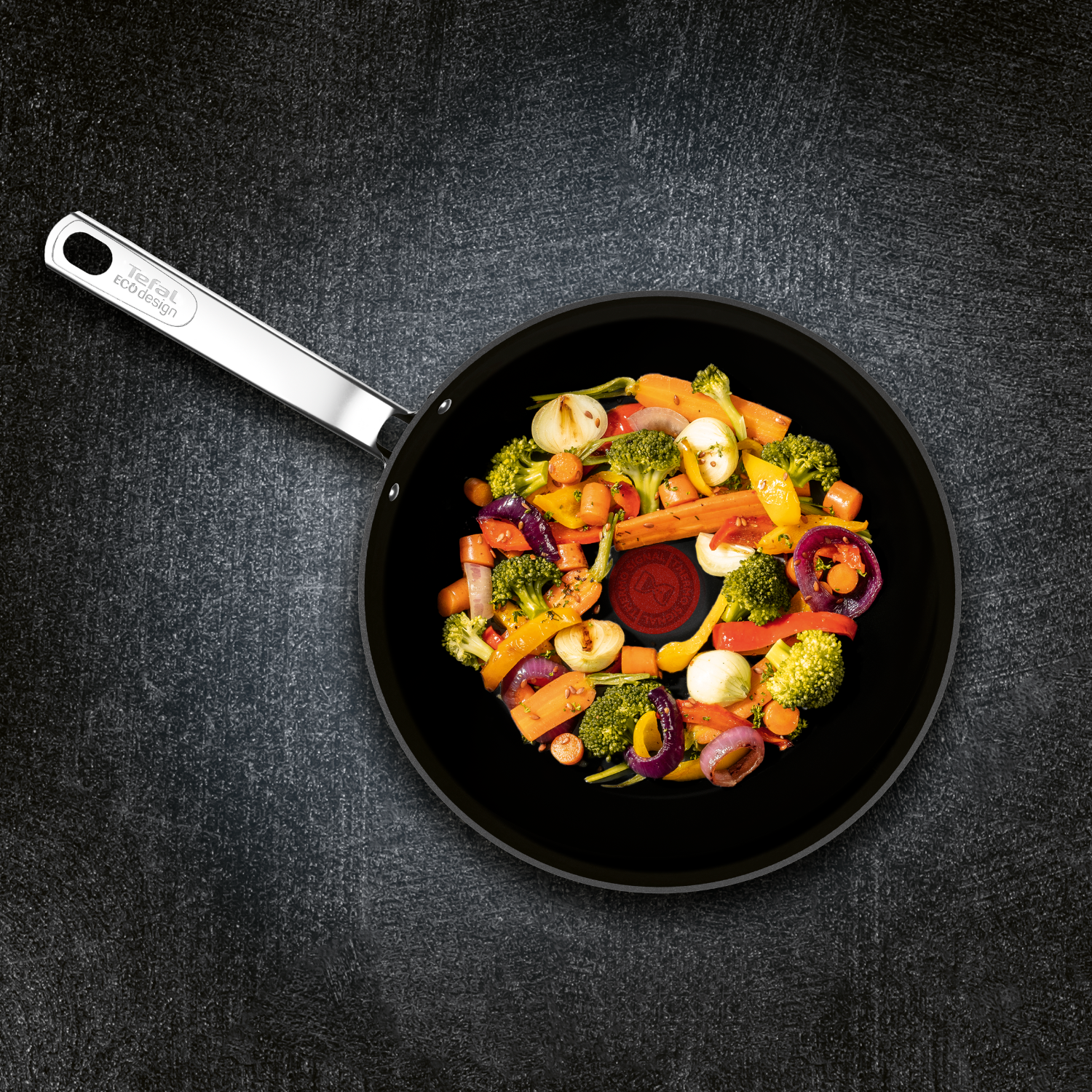 Frying pan with vegetables. Carrots, onions, broccoli, and other vegetables are cooked.