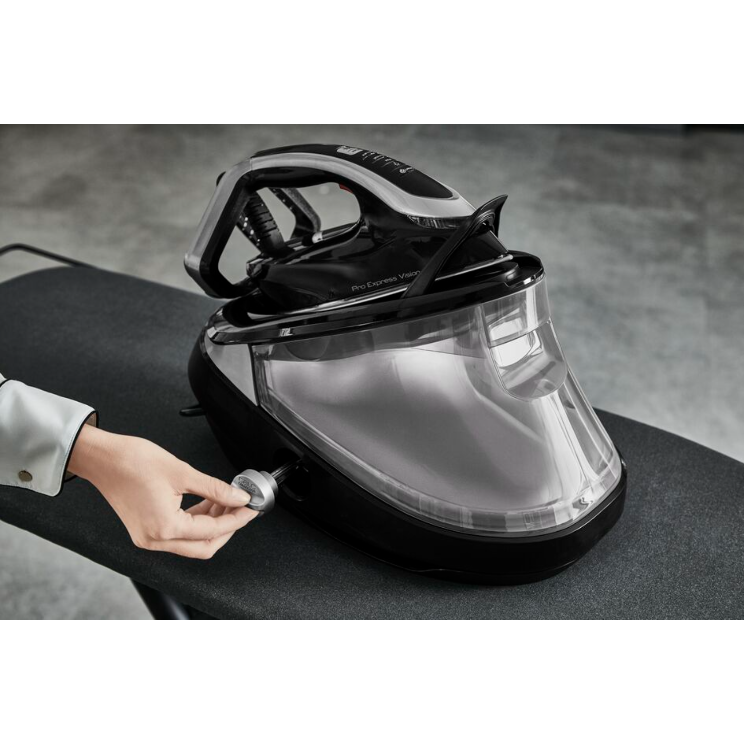 Ironing station with woman's hand adjusting a setting on the front.