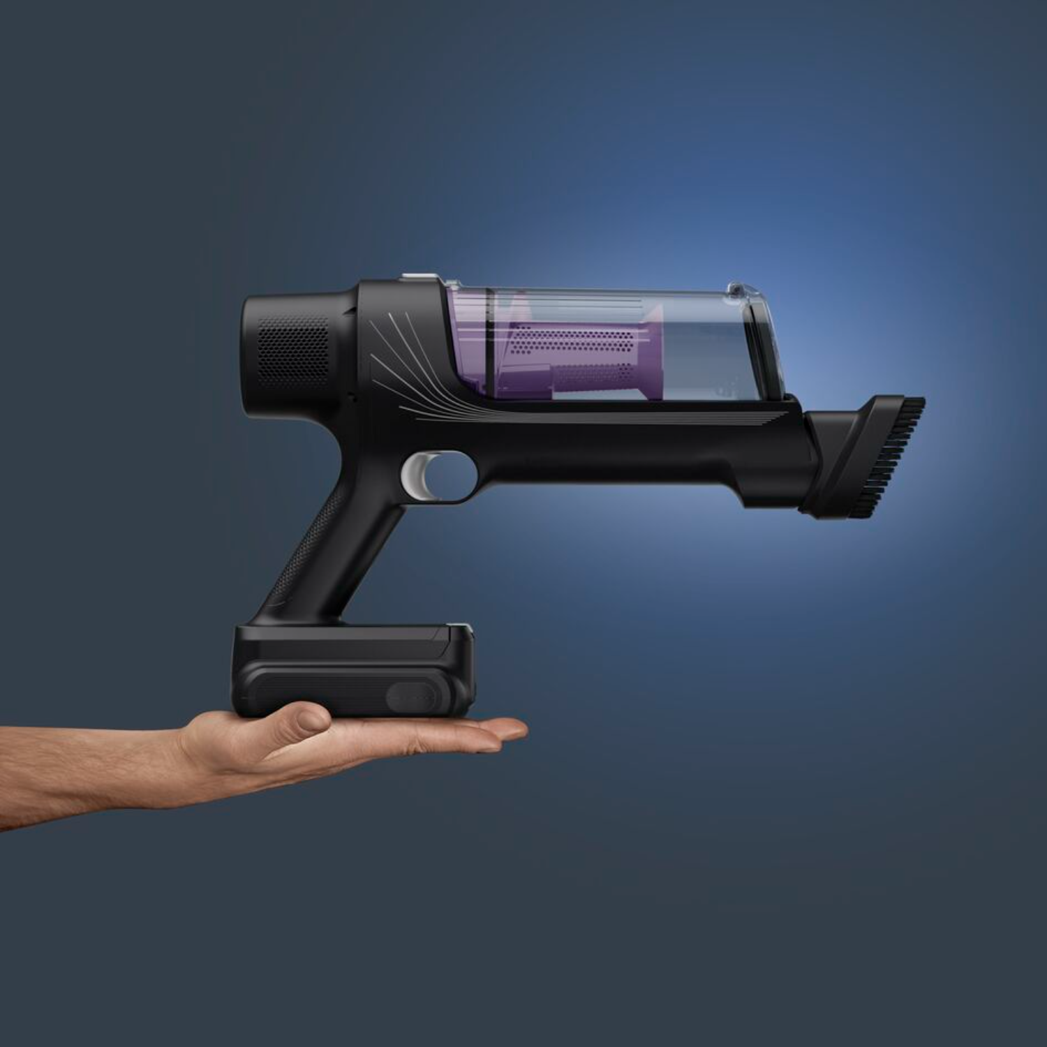 Black cordless vacuum cleaner, held by hand, transparent dust container.