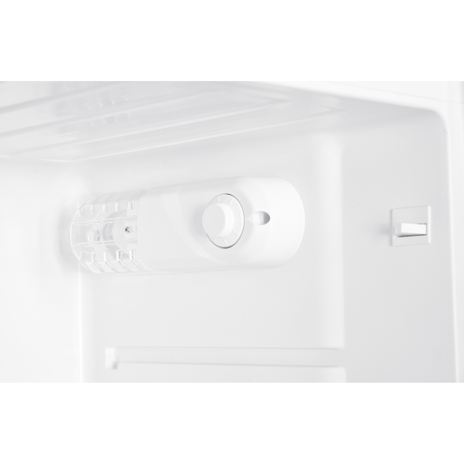 White interior of a refrigerator with a dial and a grid, showing a simple, clean design.
