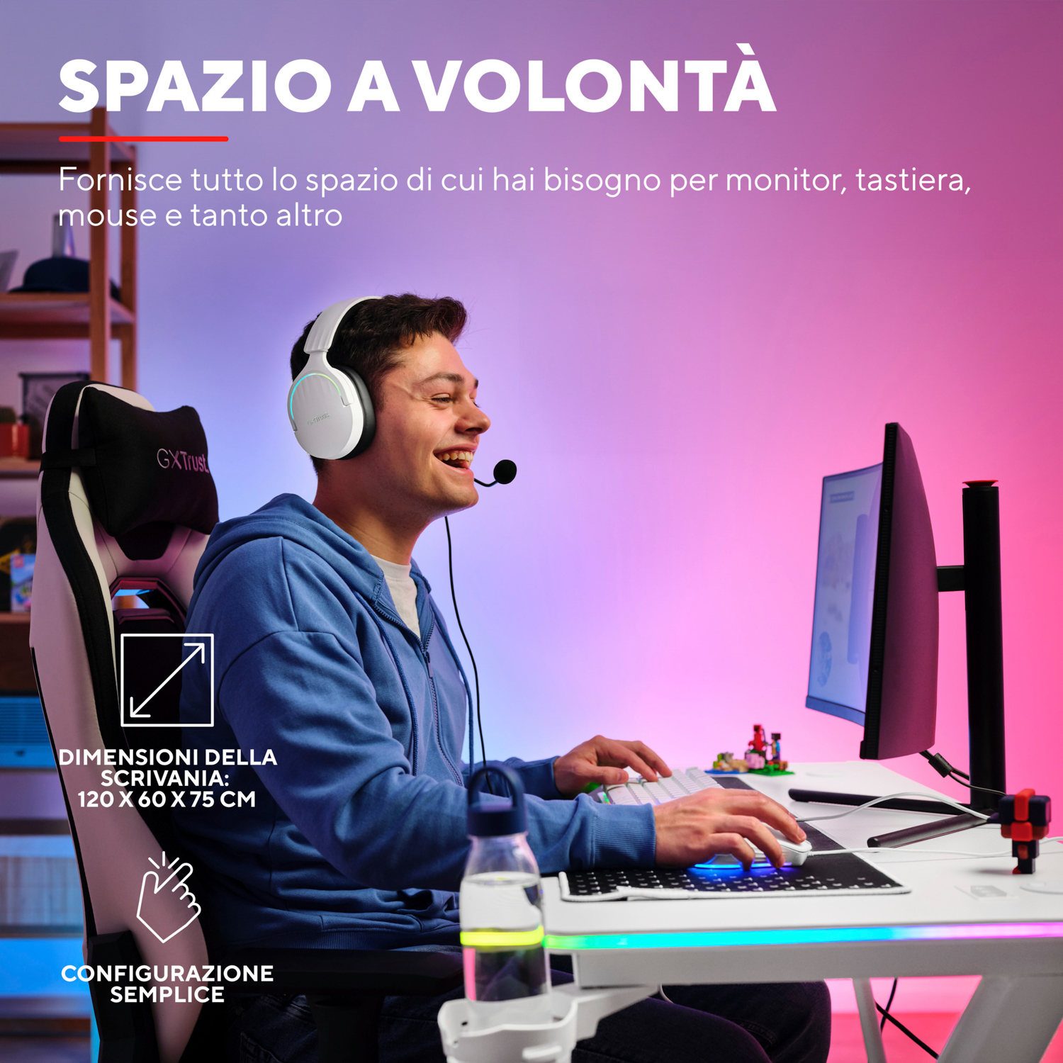 Un uomo sorride mentre gioca a un tavolo, il tavolo ha un monitor e una tastiera.