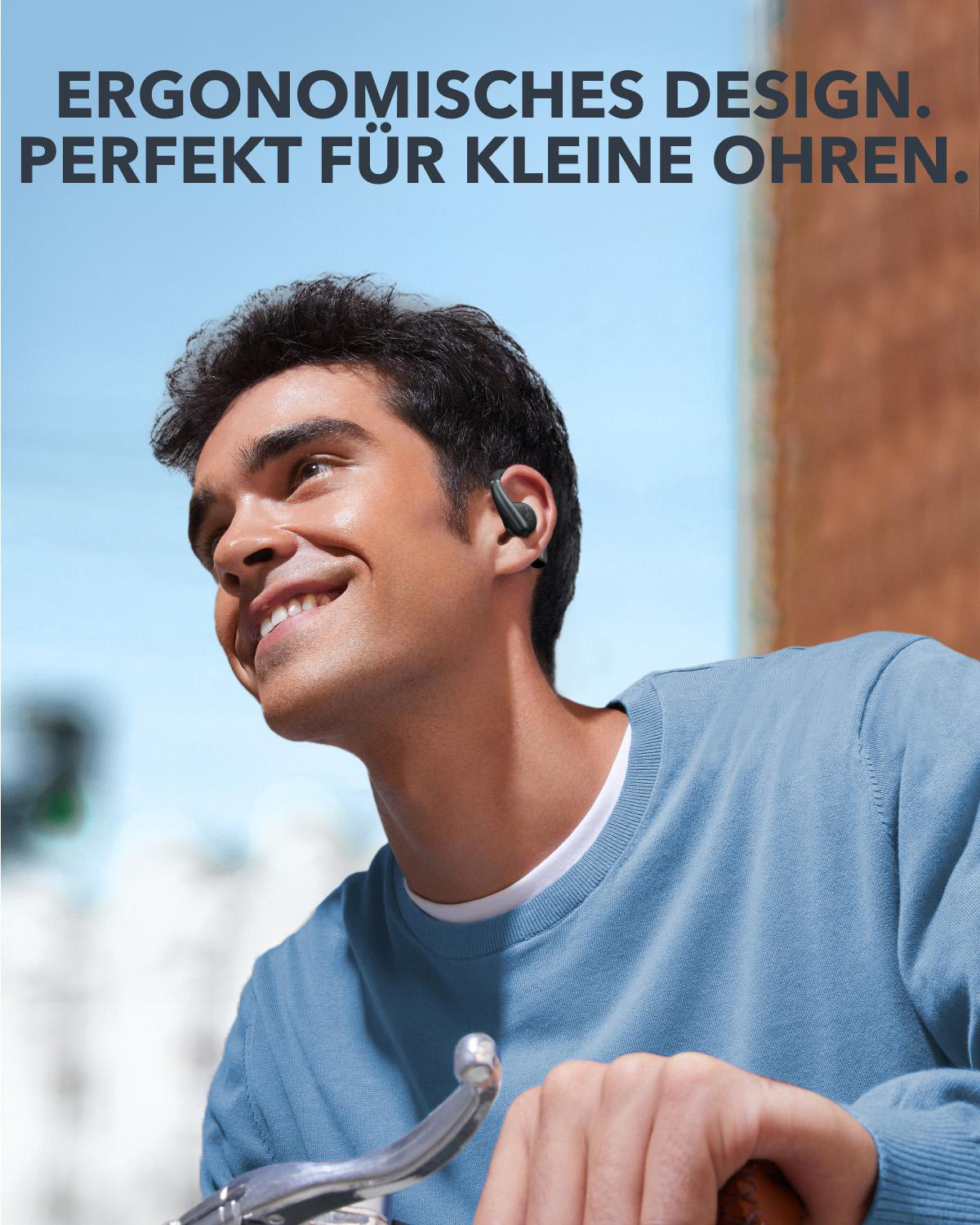 Mann lächelt, trägt schwarze Ohrhörer, Werbetext: Ergonomisches Design, perfekt für kleine Ohren.