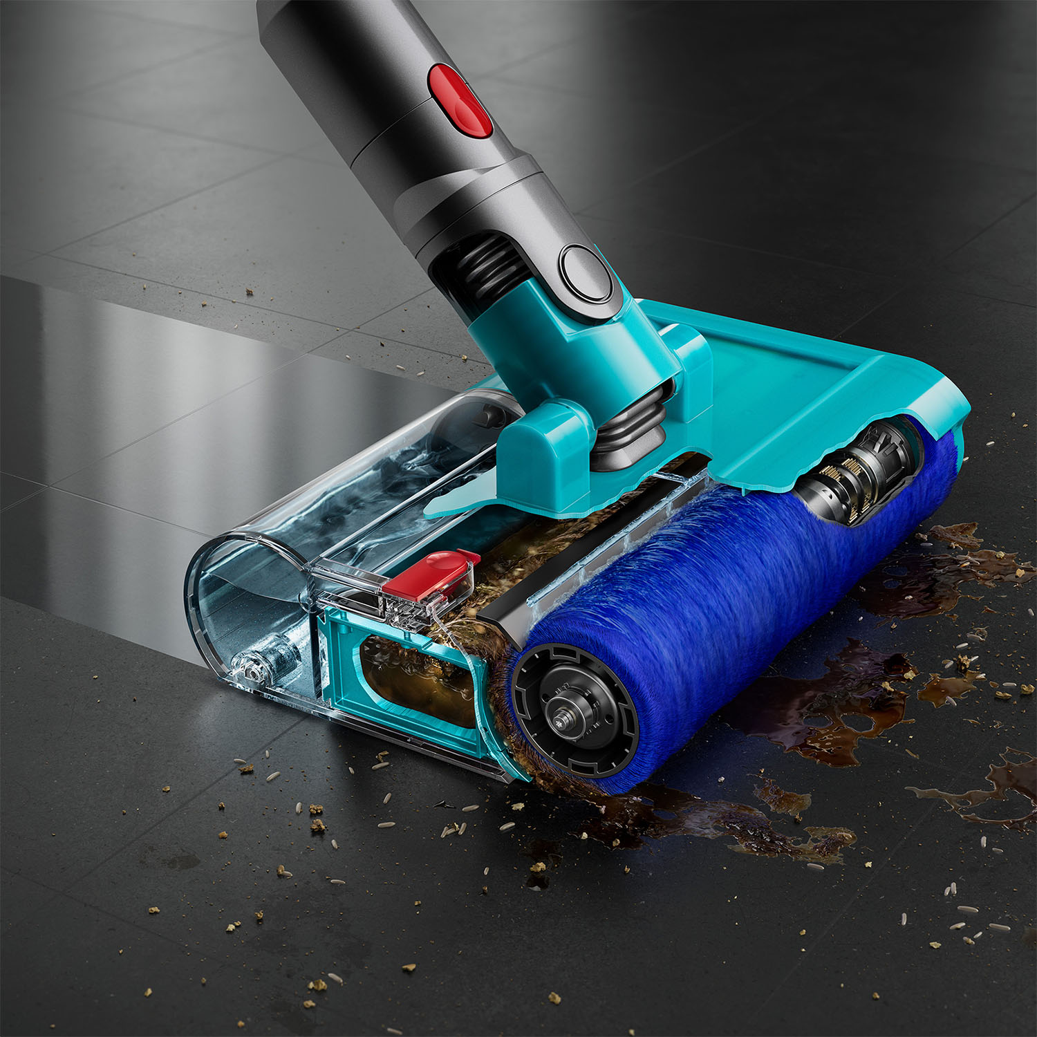 Una testa di aspirapolvere verde acqua e grigia con una spazzola blu su un pavimento di piastrelle scure, che pulisce i detriti.