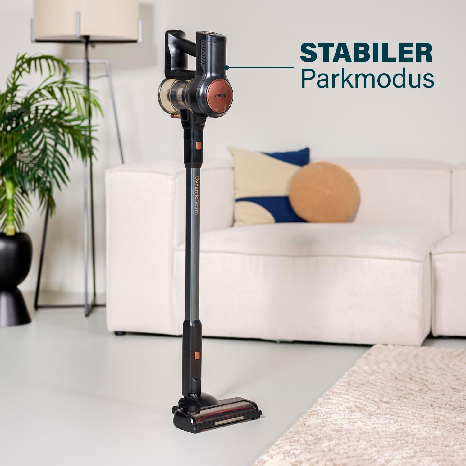 Un aspirapolvere senza fili nero e bronzo in una stanza. L'etichetta recita 'STABILER Parkmodus'.