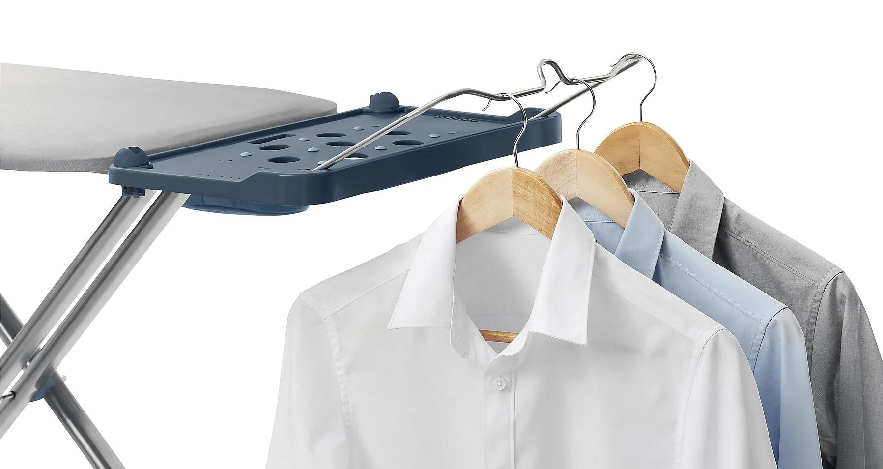 Deska do prasowania z wiszącymi koszulami. Deska po lewej, koszule po prawej.