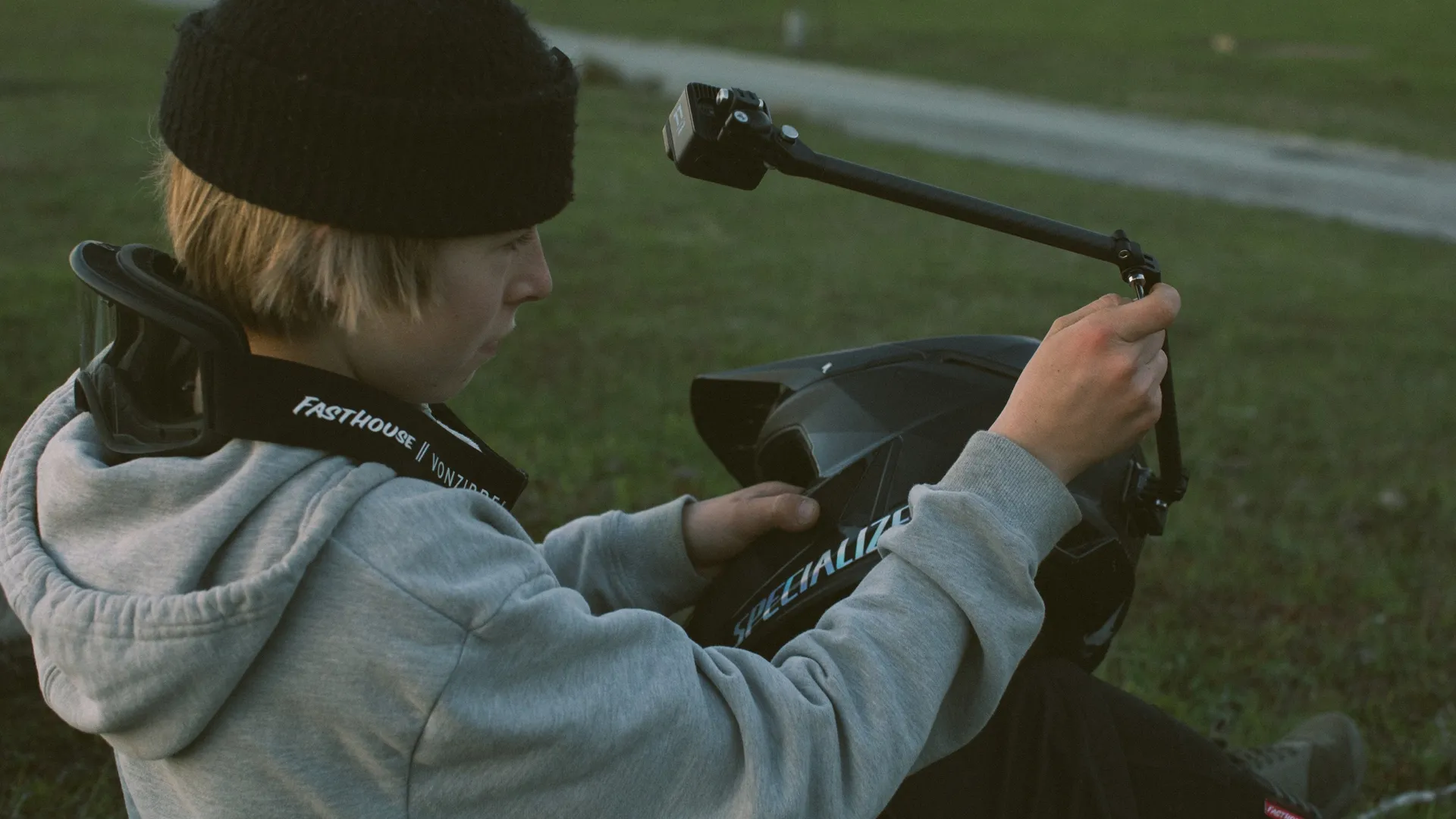 Egy személy sisakkal és GoPro kamerával a földön ül.