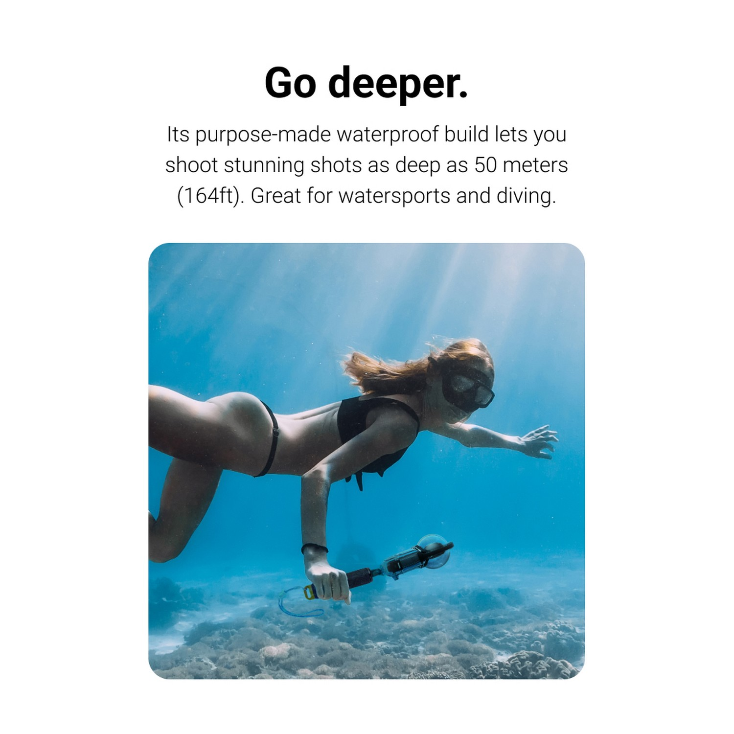Vrouw zwemt onder water met een camera. Ze draagt een masker en bikini. Helder blauw water en zonlicht.