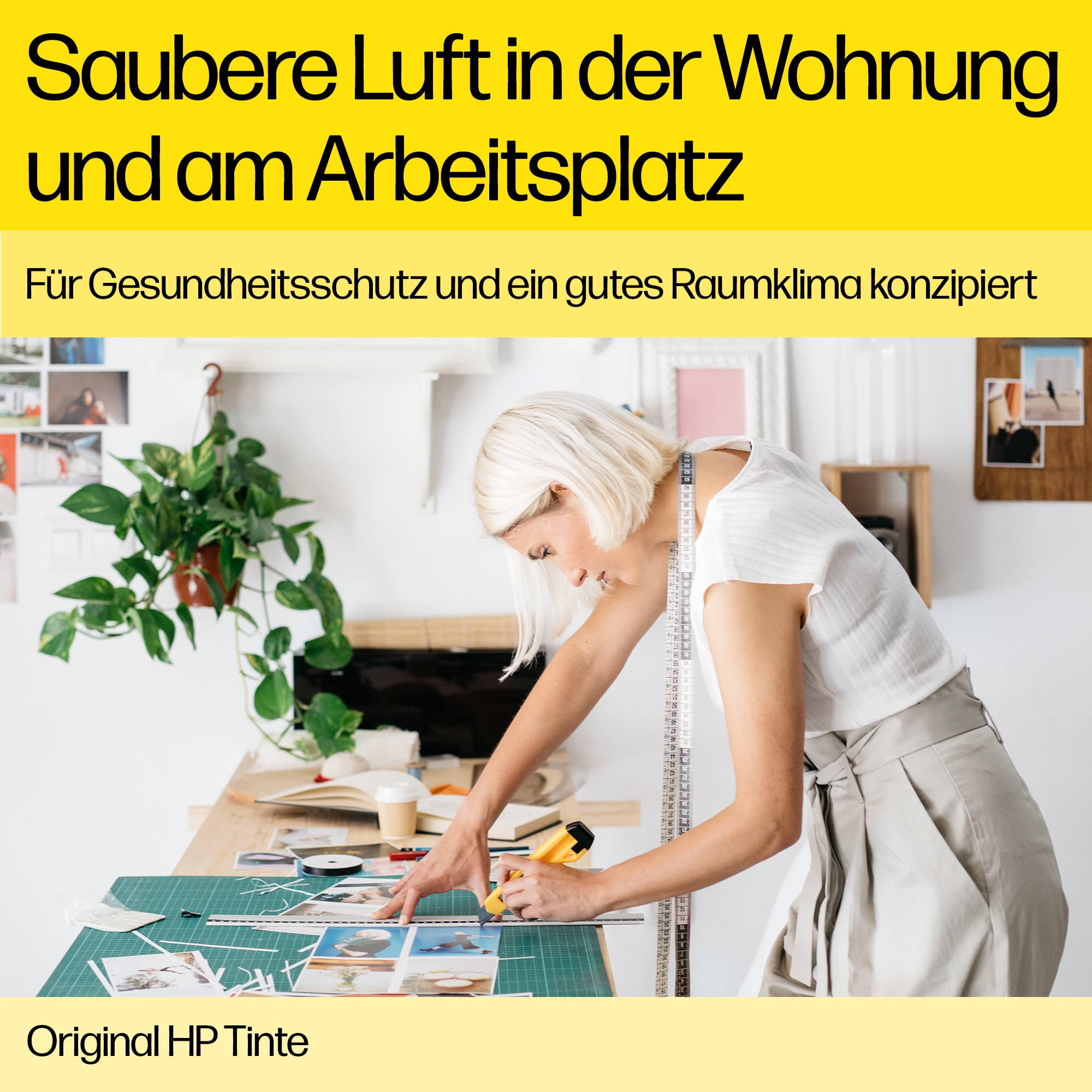 Frau schneidet Fotos an einem Schreibtisch, mit Pflanzen und einem Lineal, bewirbt saubere Luft.