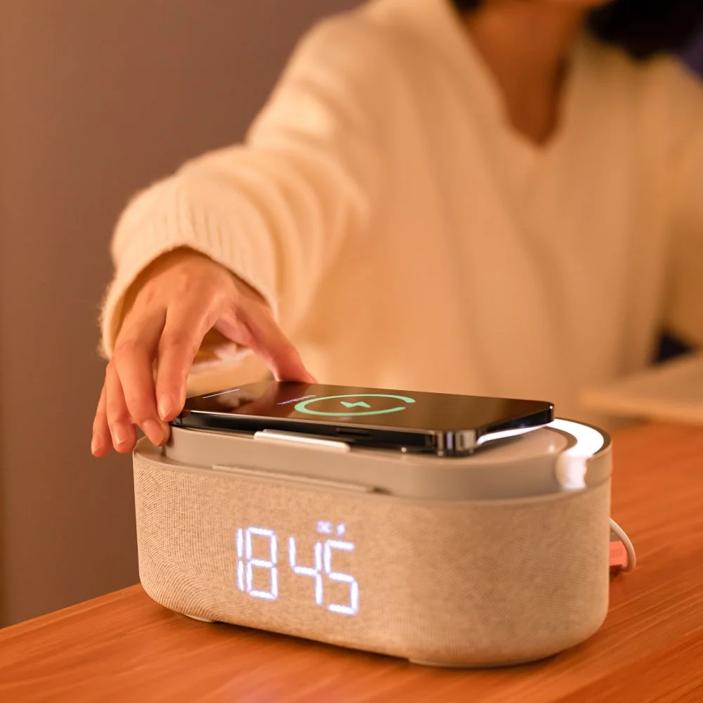 Ręka osoby umieszcza telefon na ładowarce bezprzewodowej.