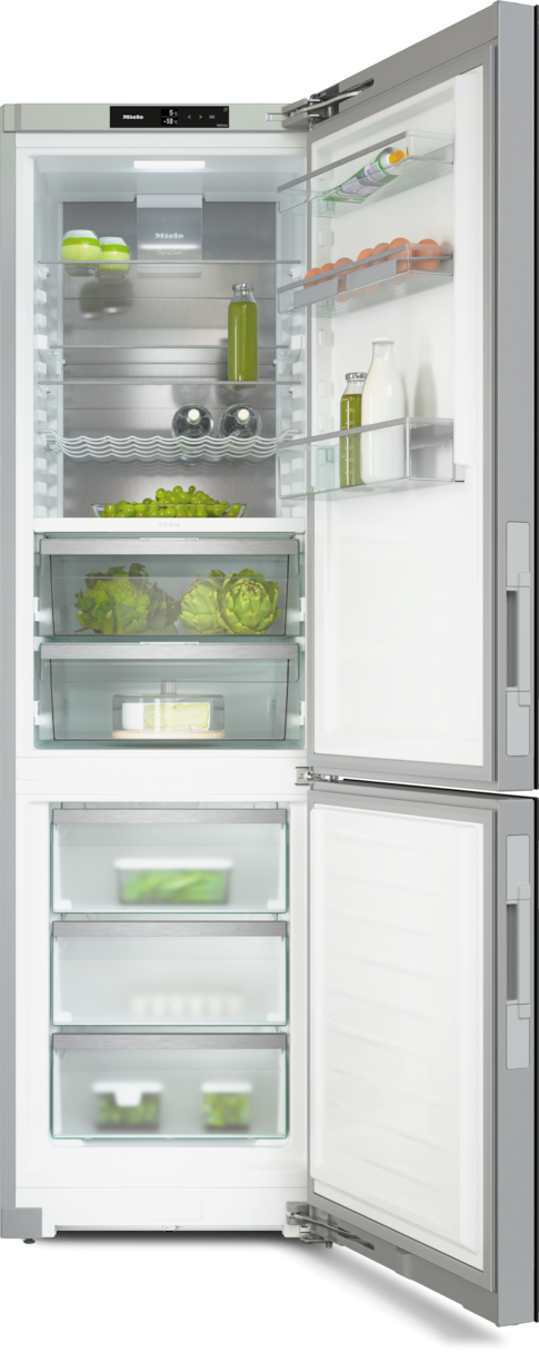 Ein Miele-Kühlschrank ist geöffnet und zeigt Regale mit Lebensmitteln und Schubladen in einem weißen Raum.