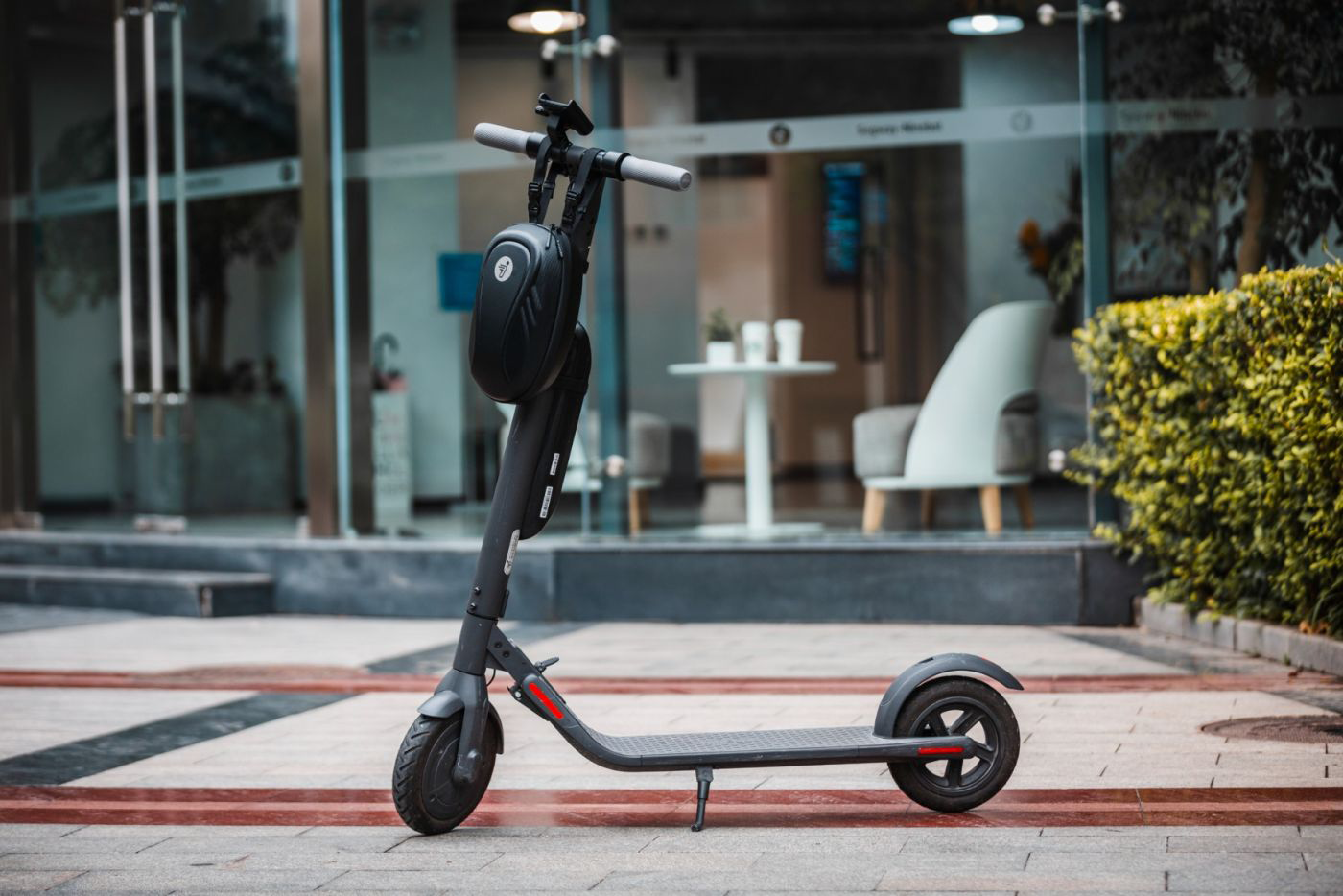 Elektromos robogó parkol téglafelületen.