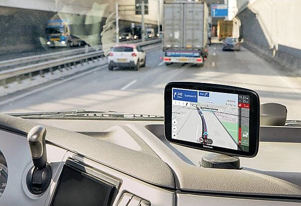 Widok z samochodu, ekran GPS pokazujący trasę na autostradzie z innymi pojazdami.