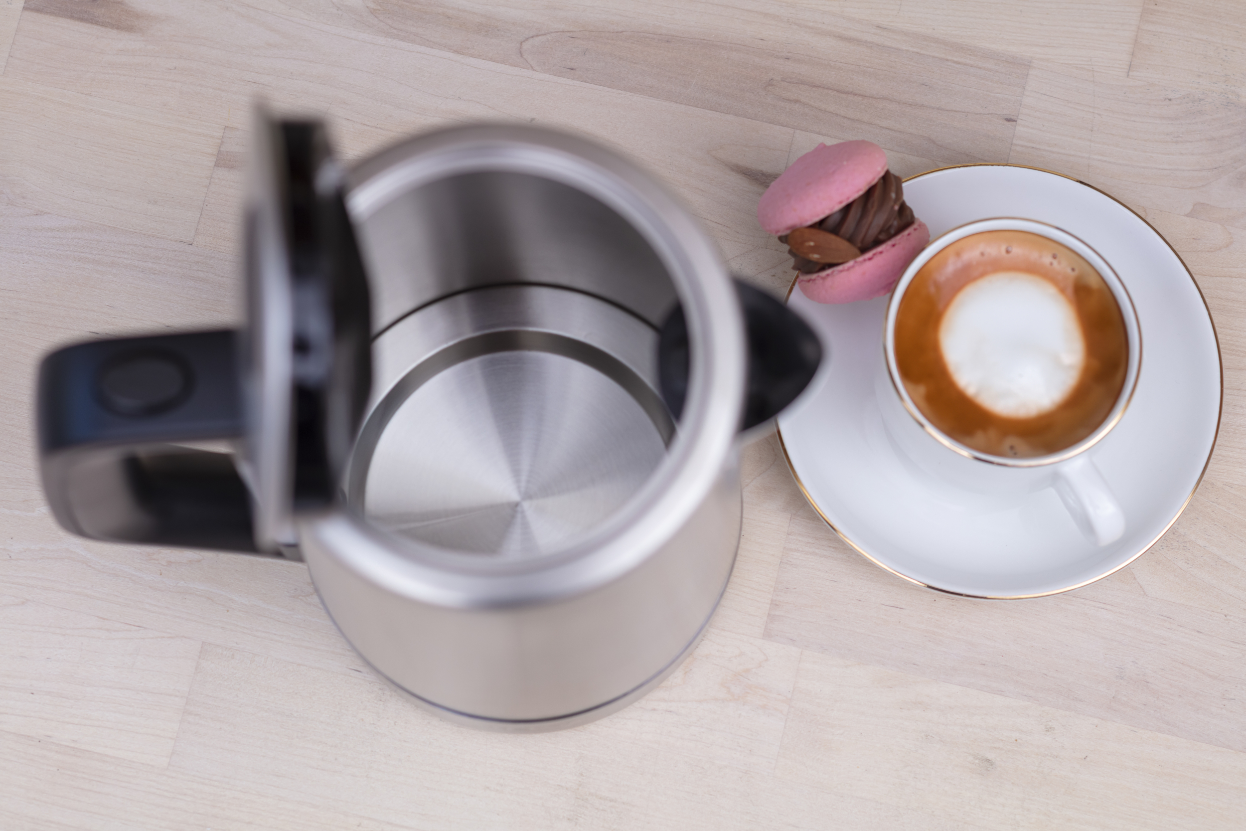 Otwarty czajnik, makaronik i kawa na drewnie.