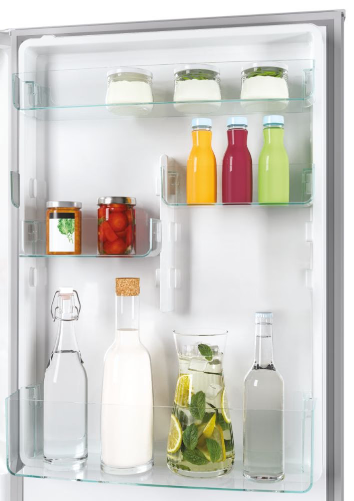 Wnętrze lodówki ze szklanymi półkami, różnymi słoikami, butelkami i płynami. Białe tło.