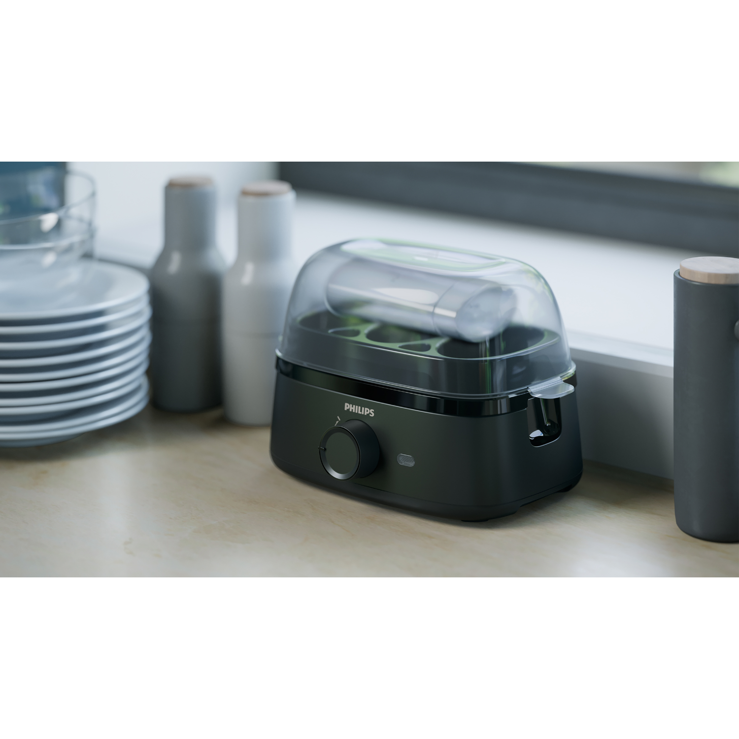 Black and clear baby bottle sterilizer on a counter.