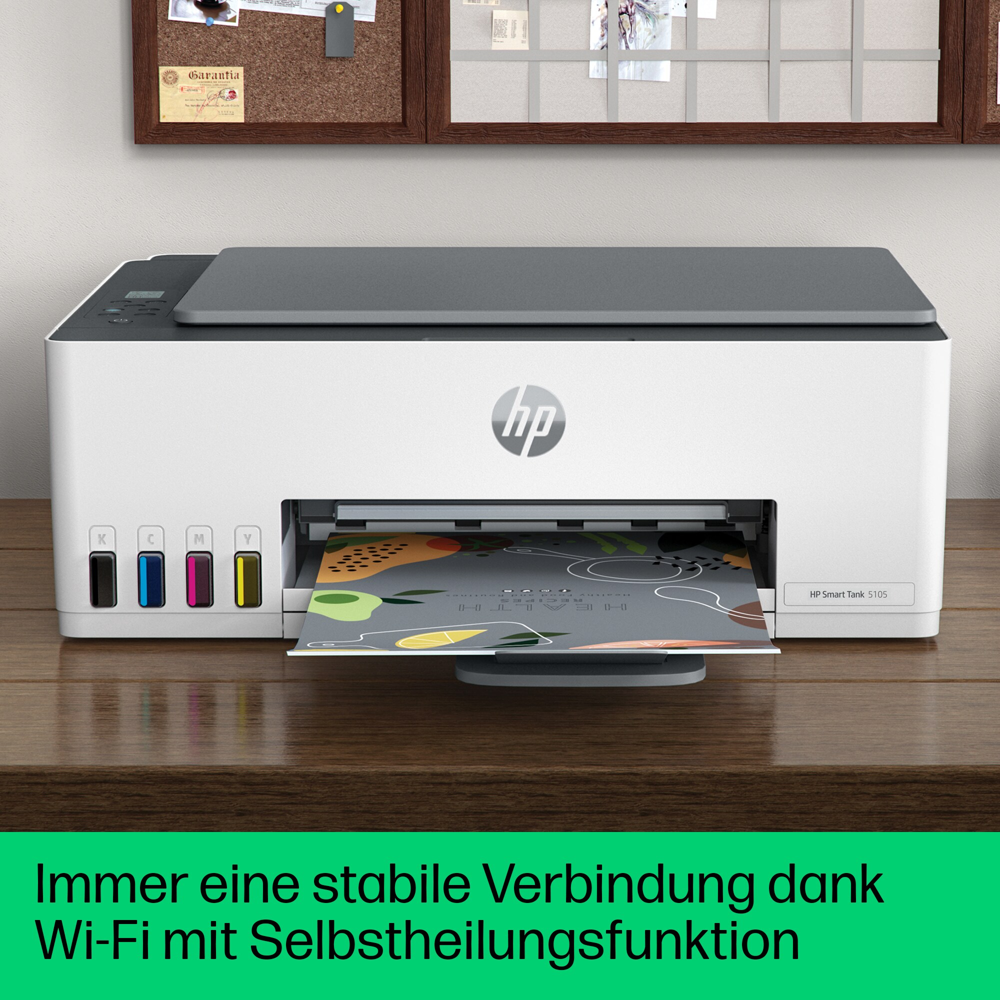 Weißer HP-Drucker mit Papierausgabe und einer Pinnwand im Hintergrund.