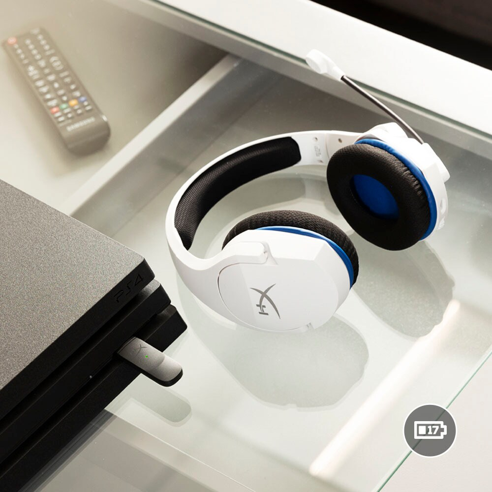 Kopfhörer, PS4 und Fernbedienung auf Glastisch. Kopfhörer sind weiß mit blauen Akzenten.