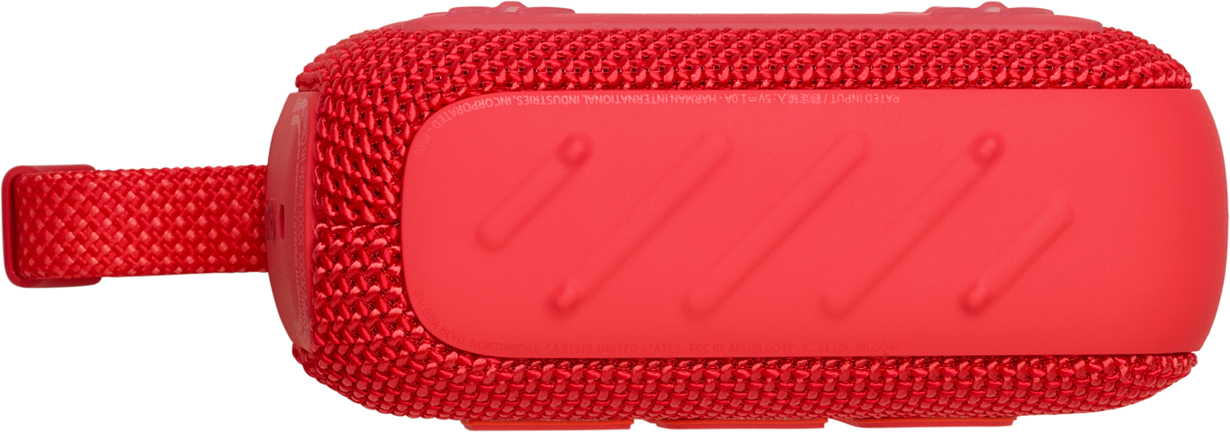 Une enceinte portable rouge avec une sangle de transport. Elle a une surface texturée.