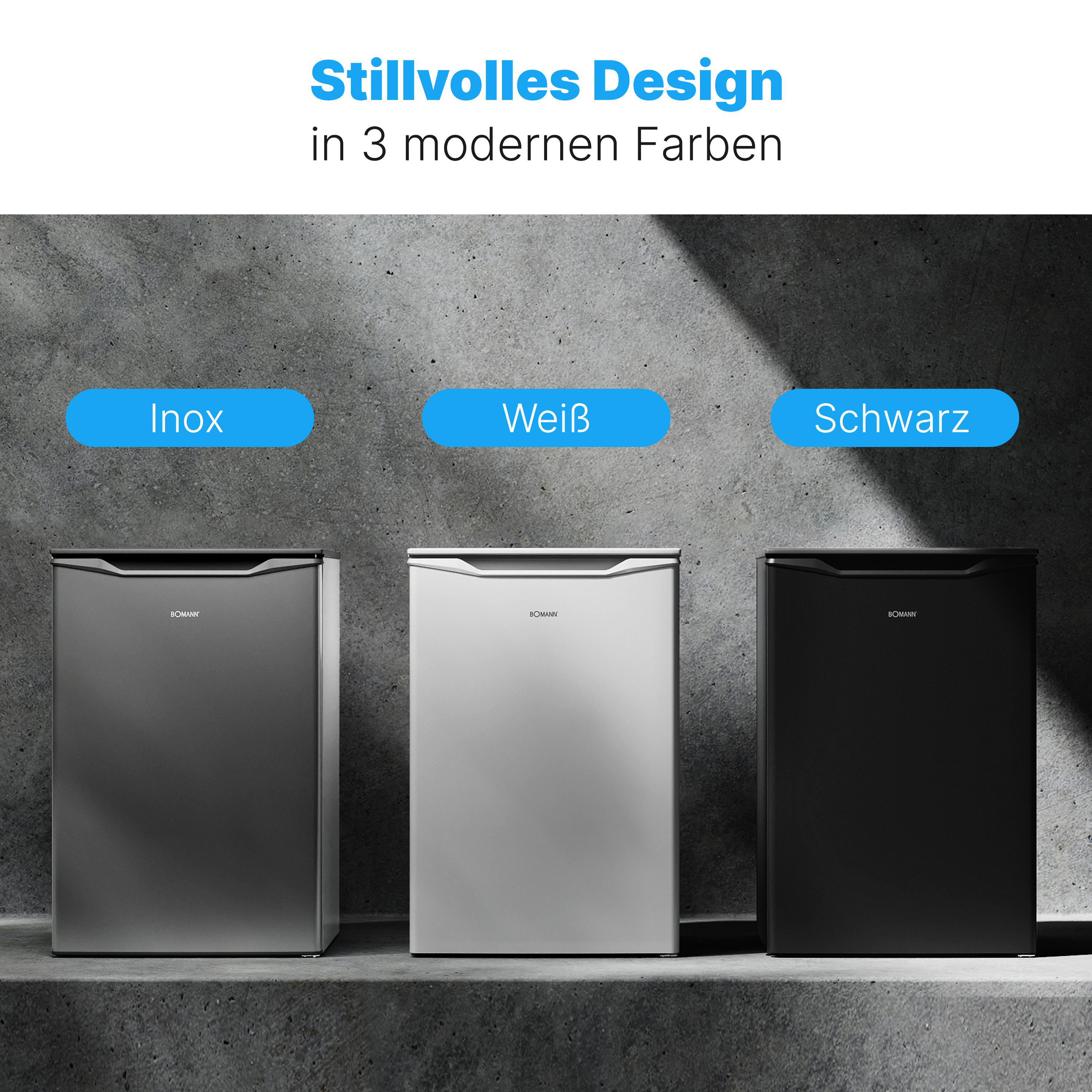 Drei kleine Kühlschränke in Grau, Weiß und Schwarz vor einer grauen Wand.