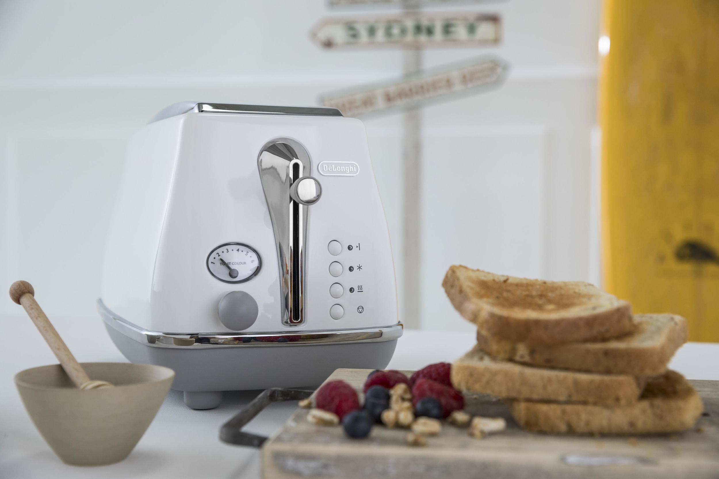 Biały toster z timerem, tostem i jagodami z drewnianą łyżką.