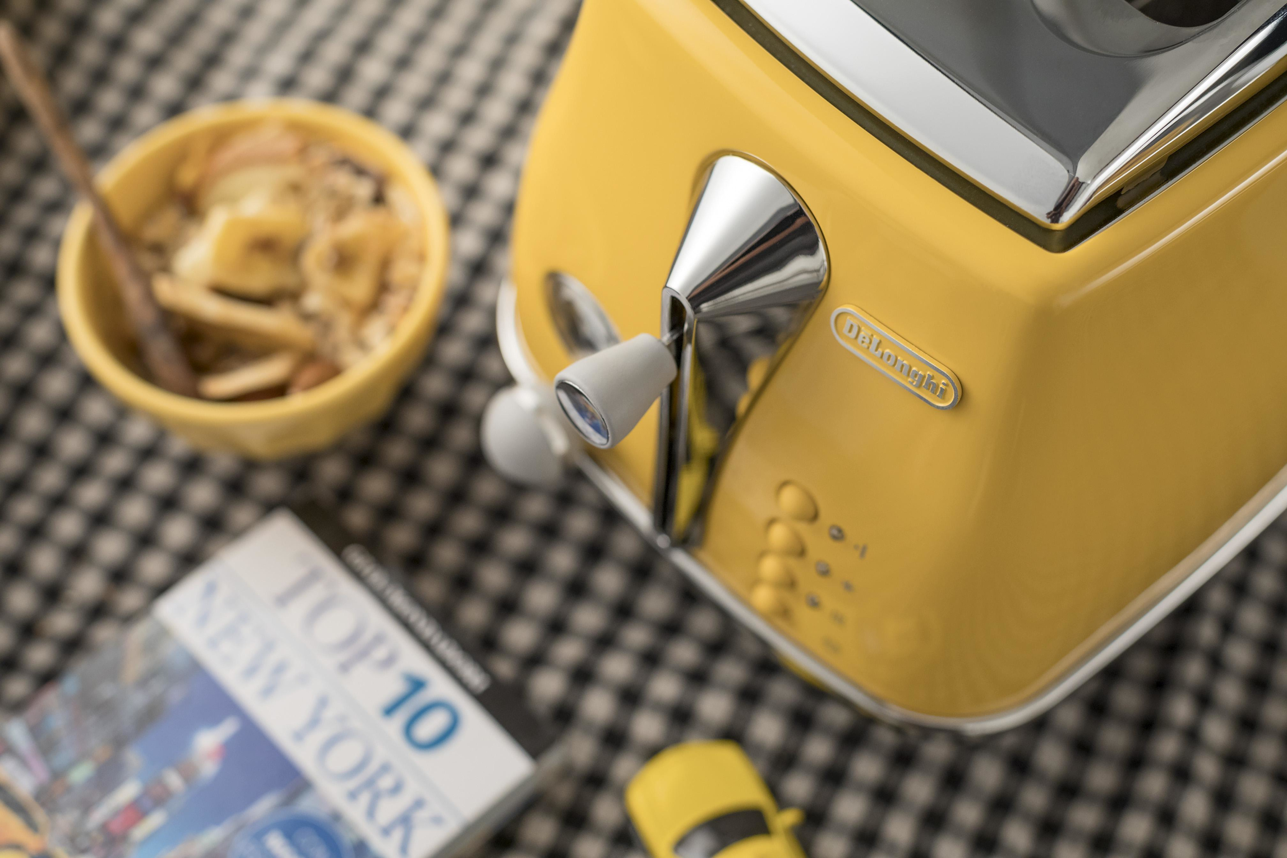 Żółty toster z miską płatków śniadaniowych i magazynem.