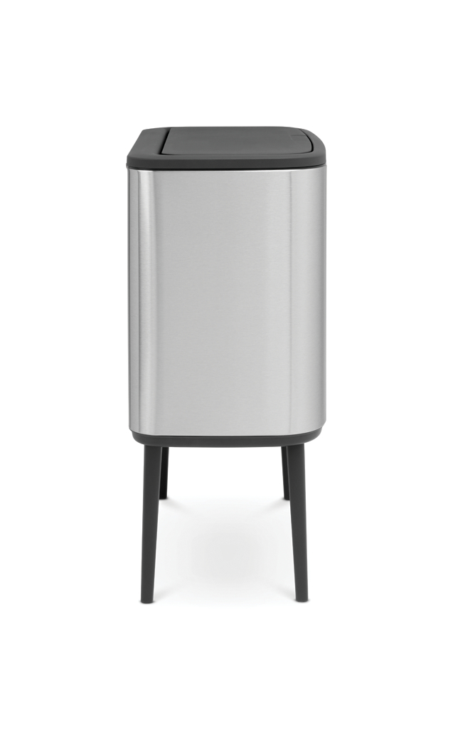Silberfarbener und schwarzer Brabantia-Mülleimer auf schwarzen Beinen, mit schwarzem Deckel.