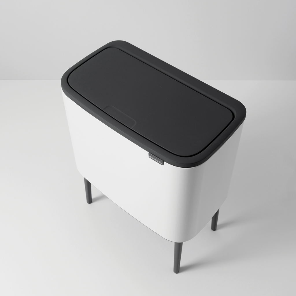 Weißer Brabantia-Mülleimer mit schwarzem Deckel und schwarzen Beinen, von oben gesehen.