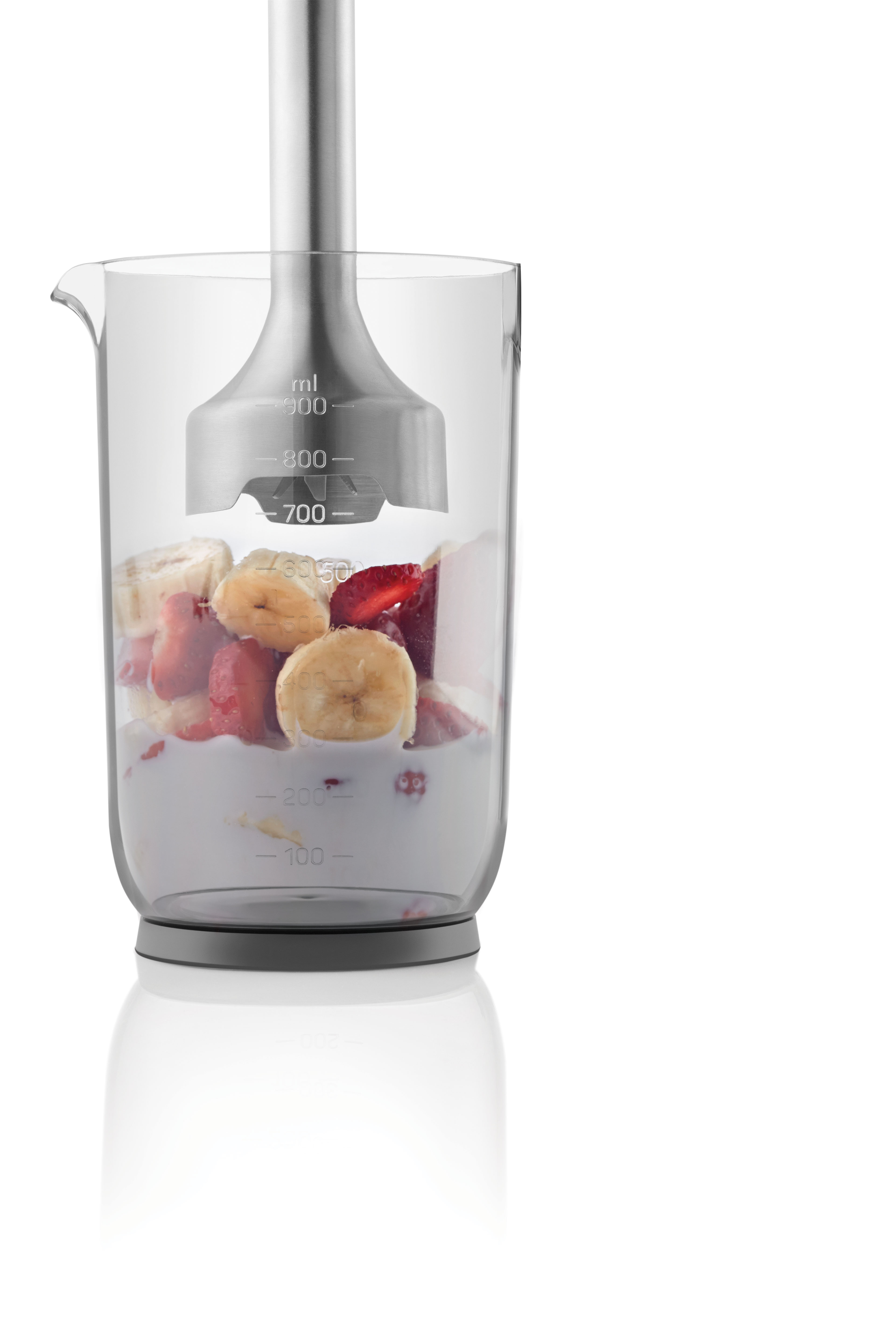Meyve ve blenderin içinde bulunduğu cam bir blender kabı. İçindekiler arasında çilek ve muz bulunur.