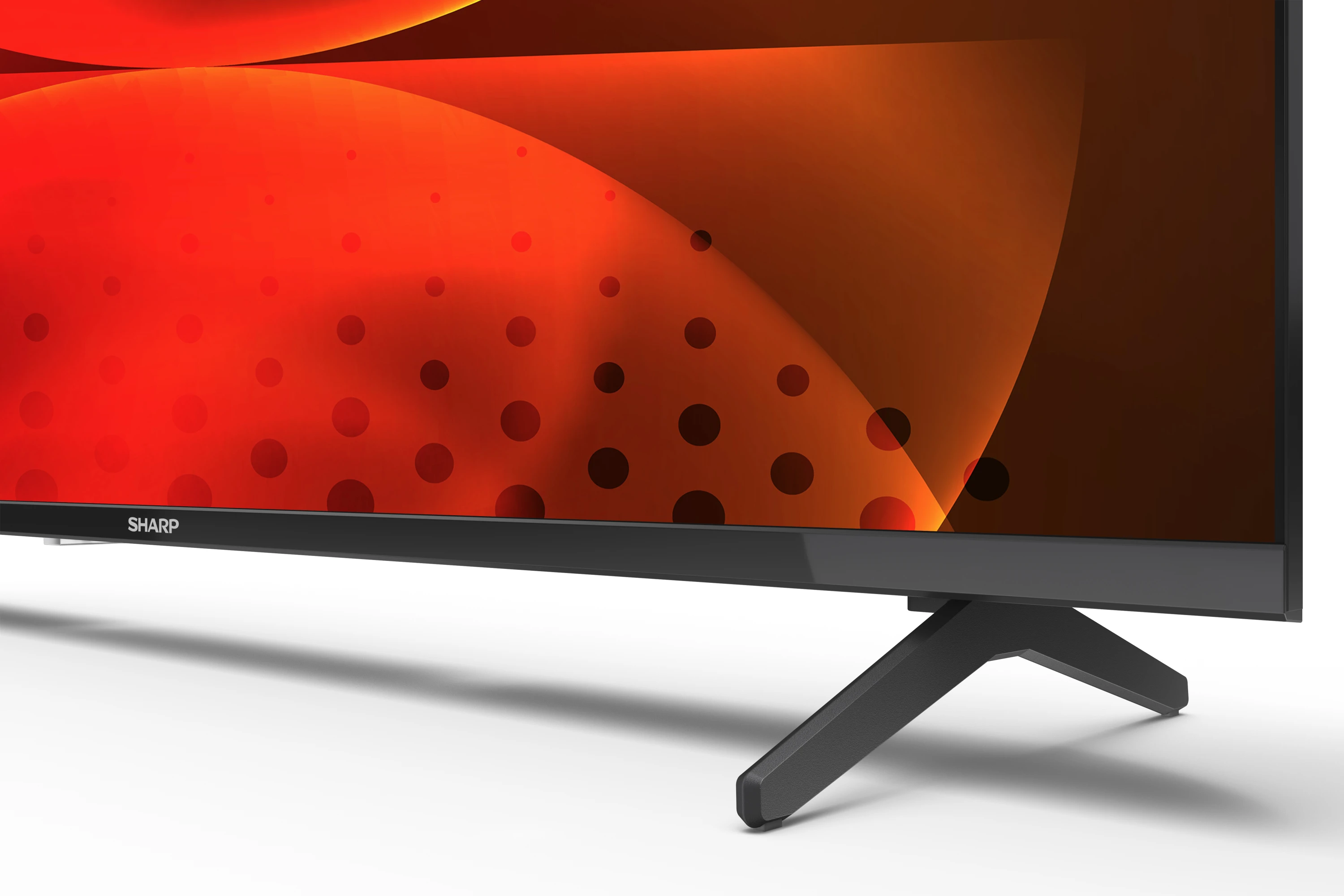 Sharp TV képernyő. Fekete keret, fekete állvány. Piros és narancssárga absztrakt háttér.