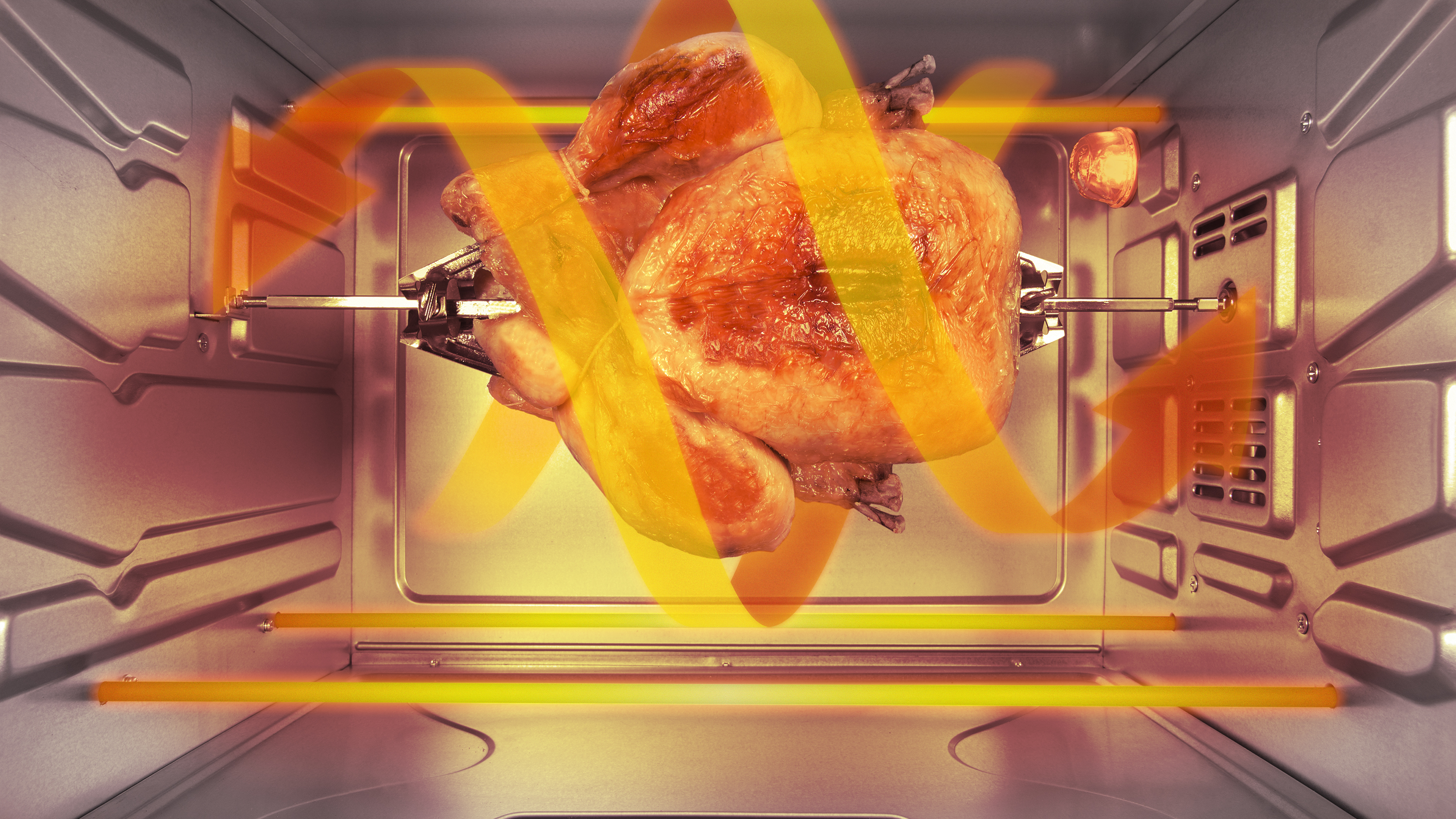 Interior de horno con pollo asado en asador. Olas de calor anaranjadas visibles.