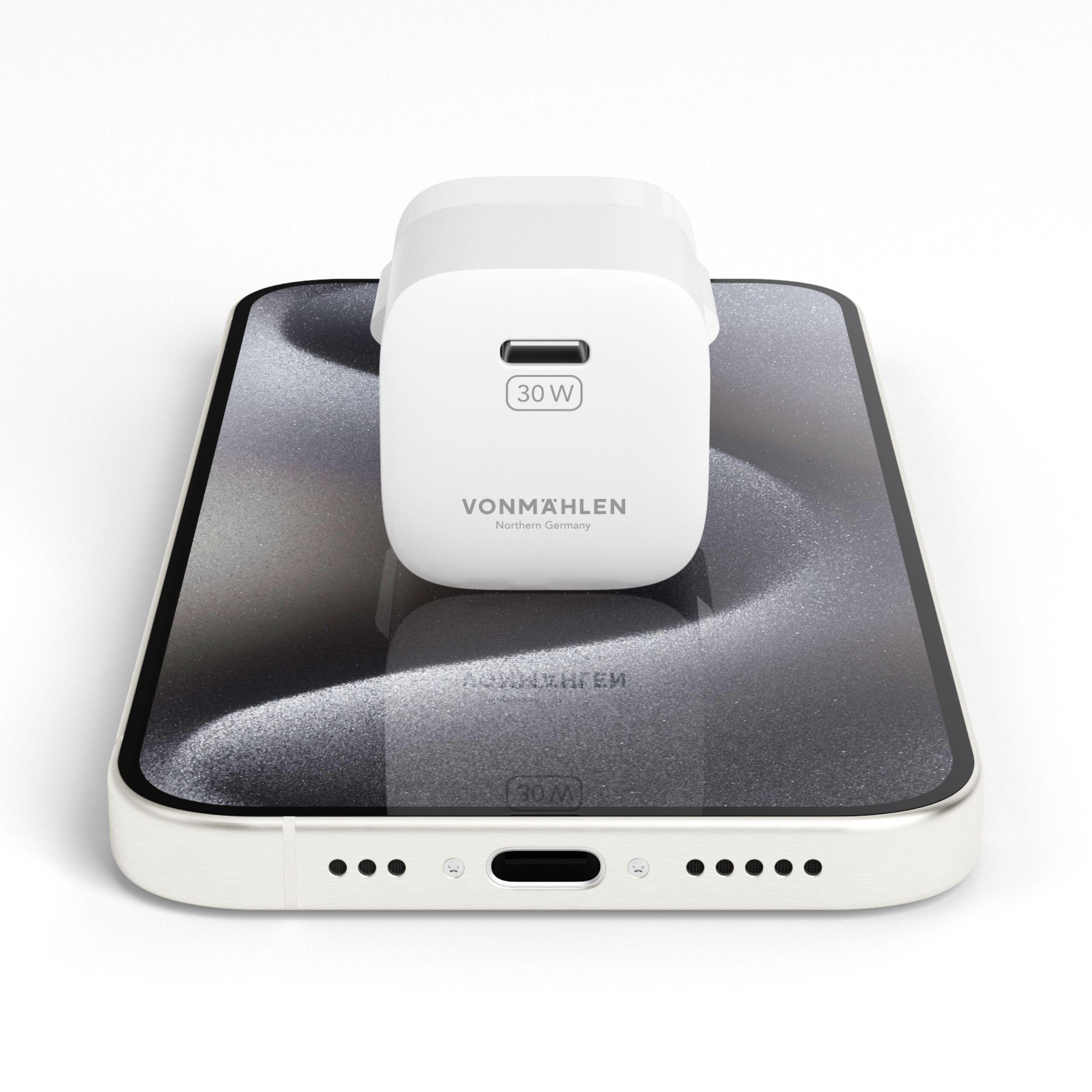 Weißes Telefonladegerät auf weißem Telefon. Ladegerät liest 30W. Weißer Hintergrund.