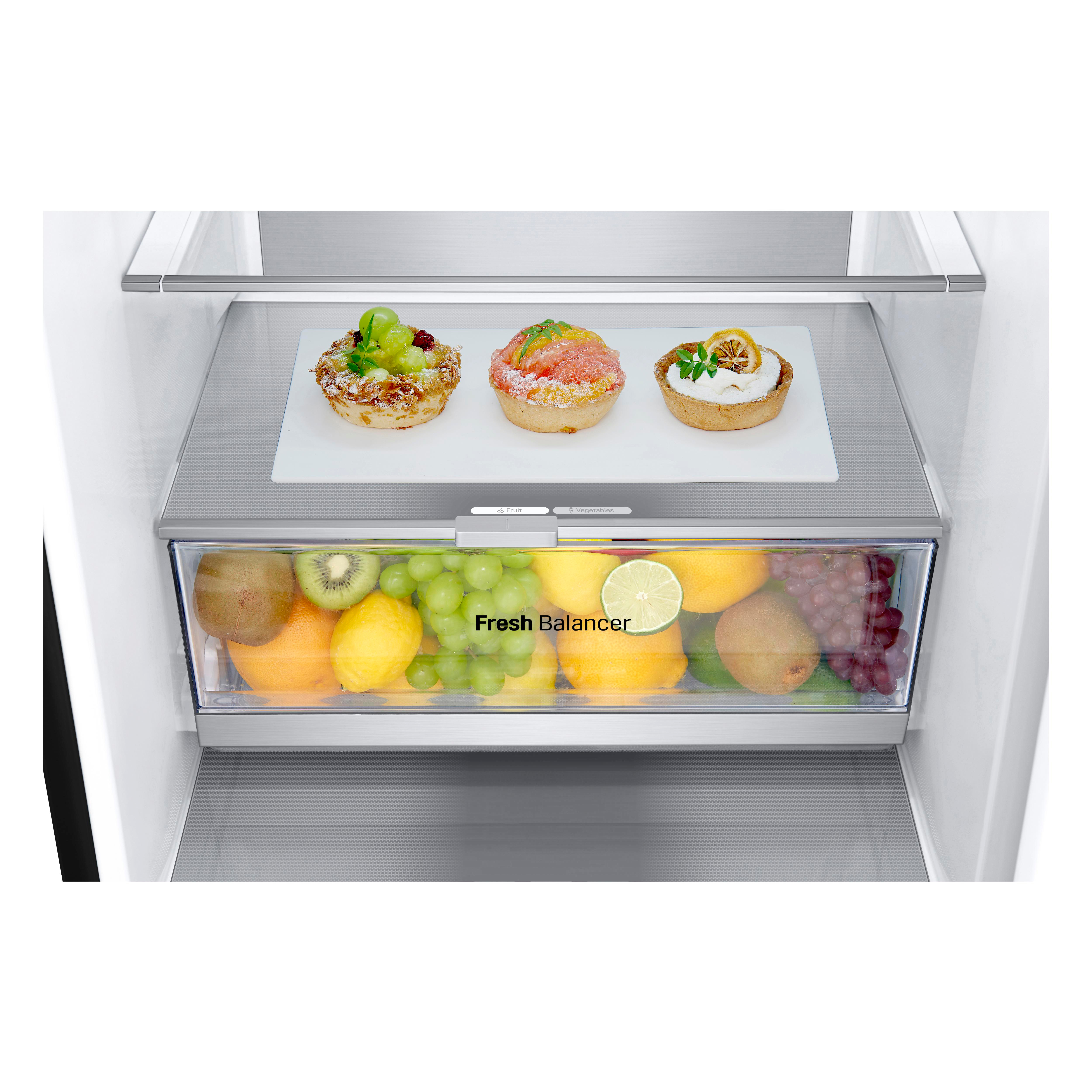 Kühlschrank-Innenraum. Oberes Regal mit Desserts, unteres mit Früchten. Weißer Hintergrund.