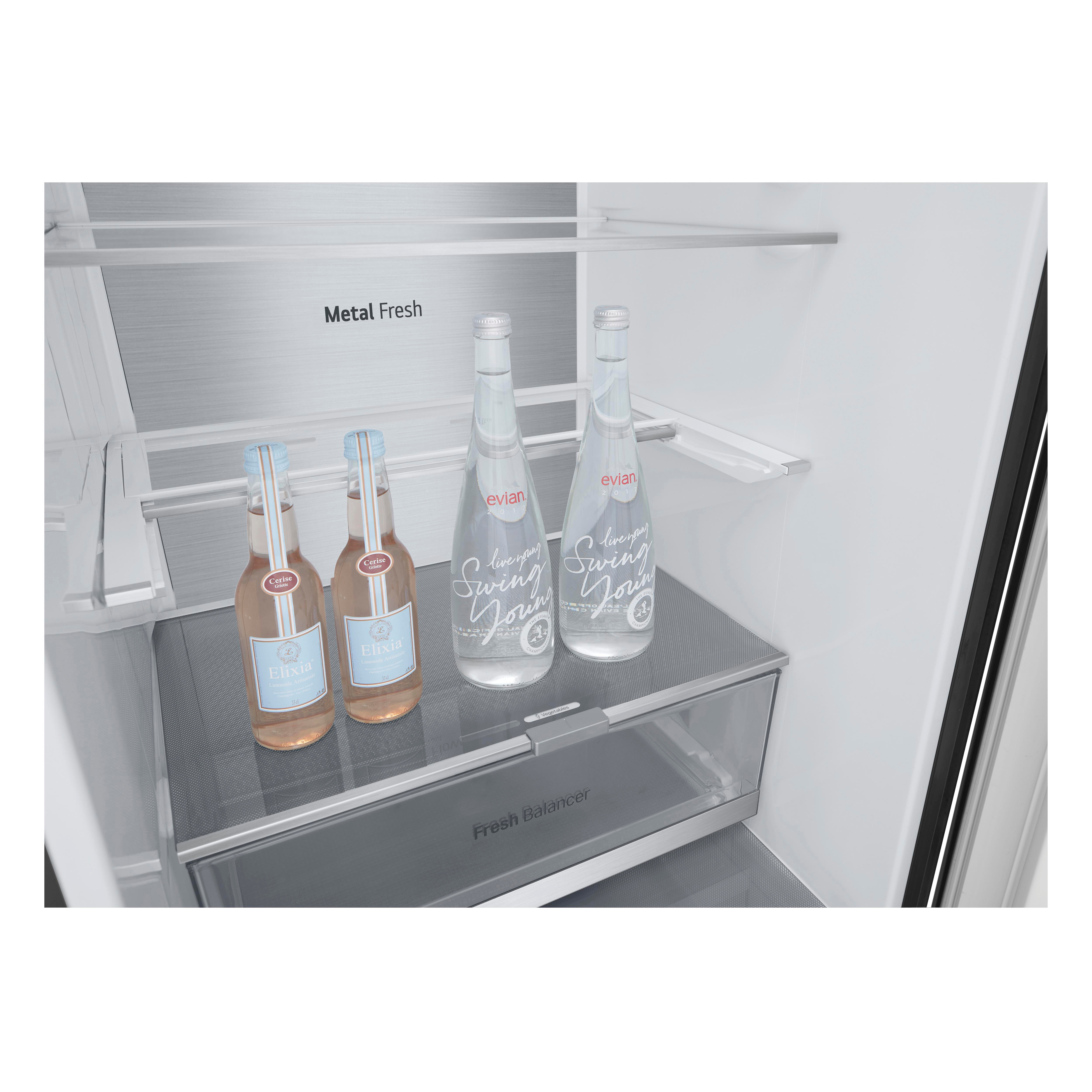 Kühlschrankinnenraum mit Flaschen auf Regalen. Zwei Evian-Flaschen und zwei Flaschen Elisia-Wasser werden gezeigt.