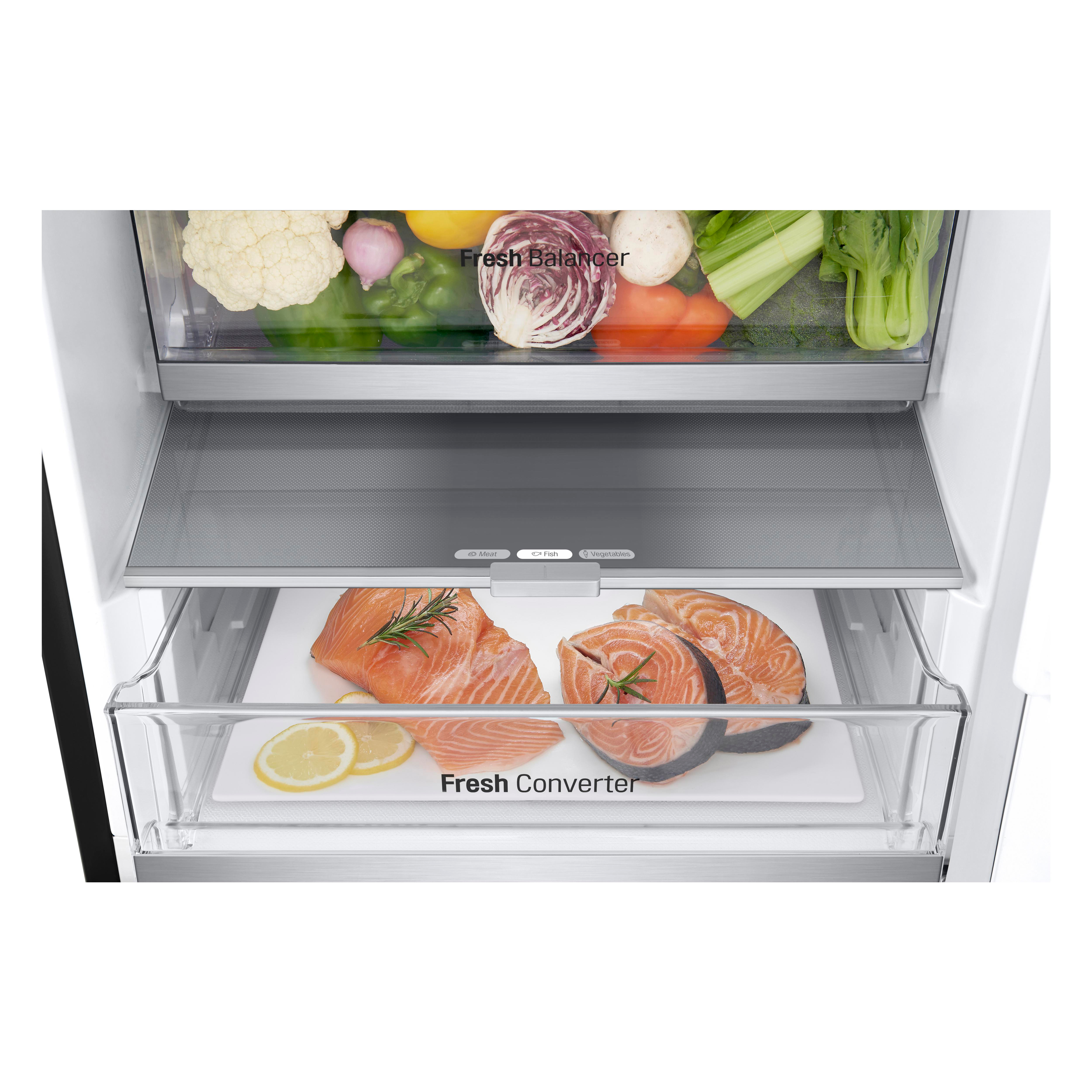 Kühlschrank-Innenraum mit Lachs und Gemüse. Lachsscheiben und Zitrone auf einem Regal.