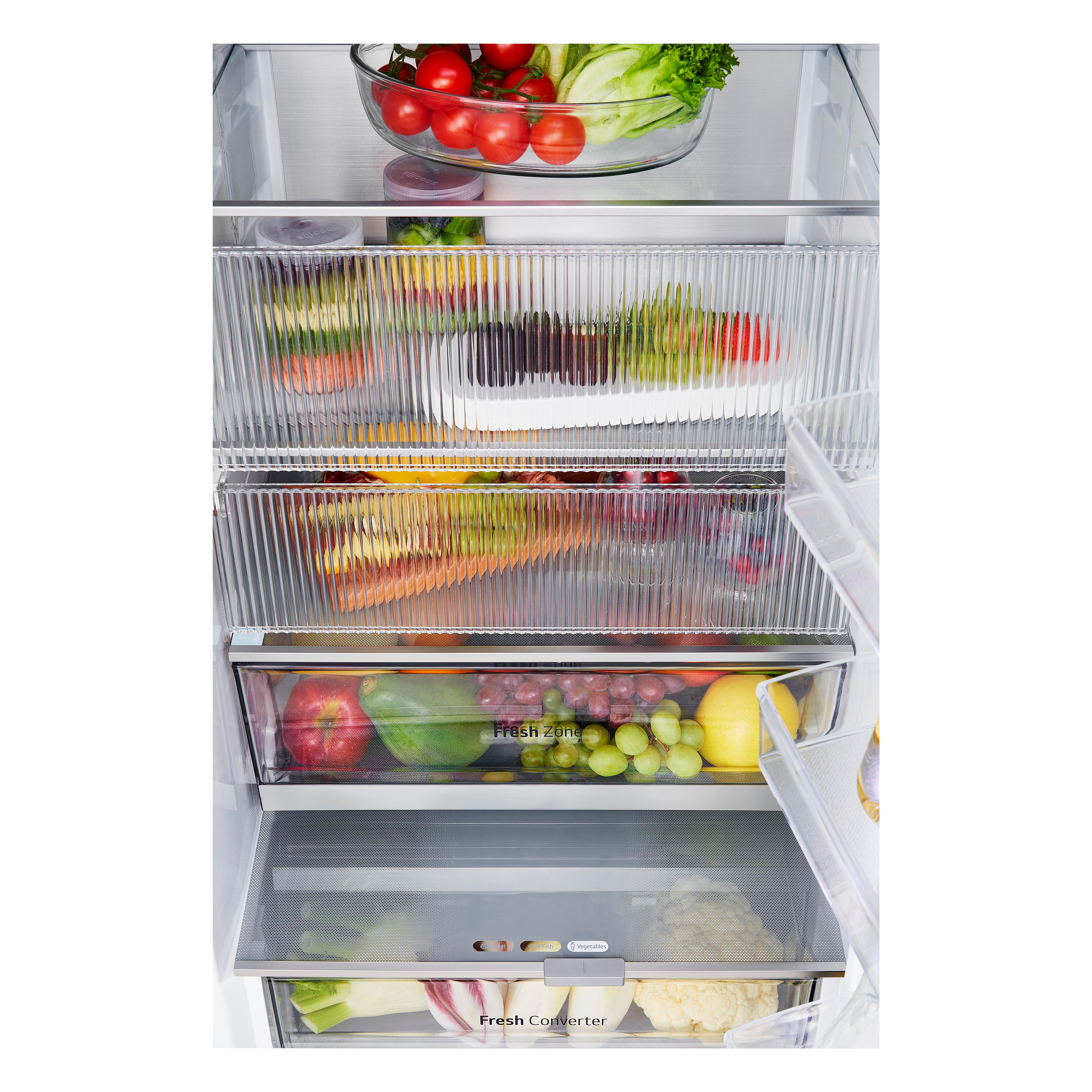 Im Kühlschrank befinden sich verschiedene Fächer mit Gemüse. Oben befindet sich eine klare Schüssel mit Tomaten.