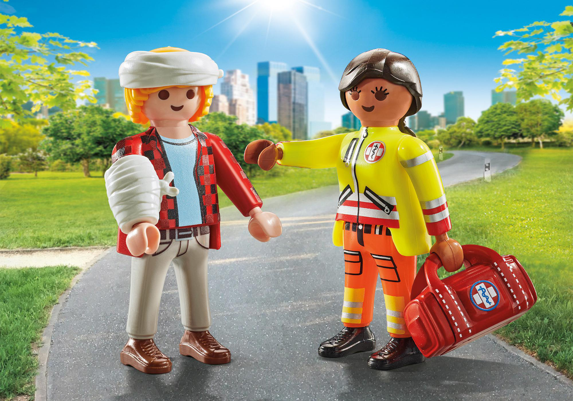 Playmobil-Figuren. Ein Mann mit Kopfverletzung und ein Arzt, der zeigt. Grüner Parkhintergrund.