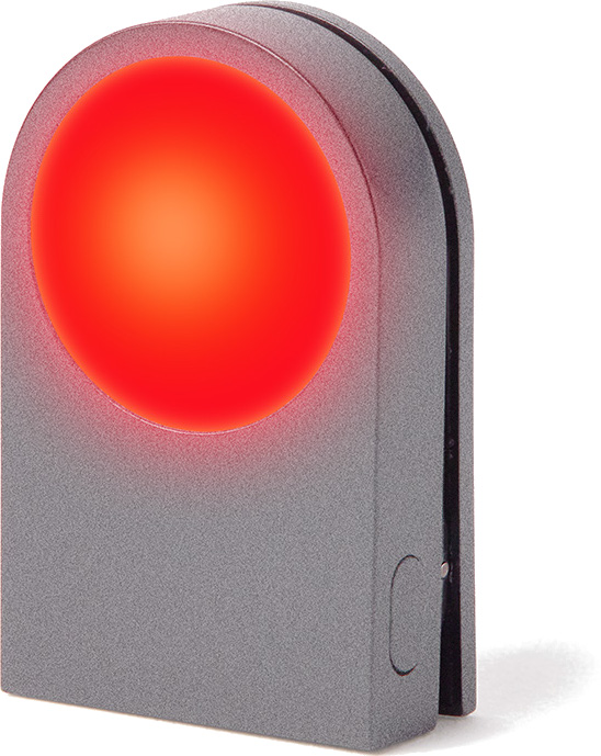 Szare urządzenie z jasno czerwoną, podświetloną okrągłą tarczą na froncie. Urządzenie ma zakrzywioną górę i mały przycisk z boku.
