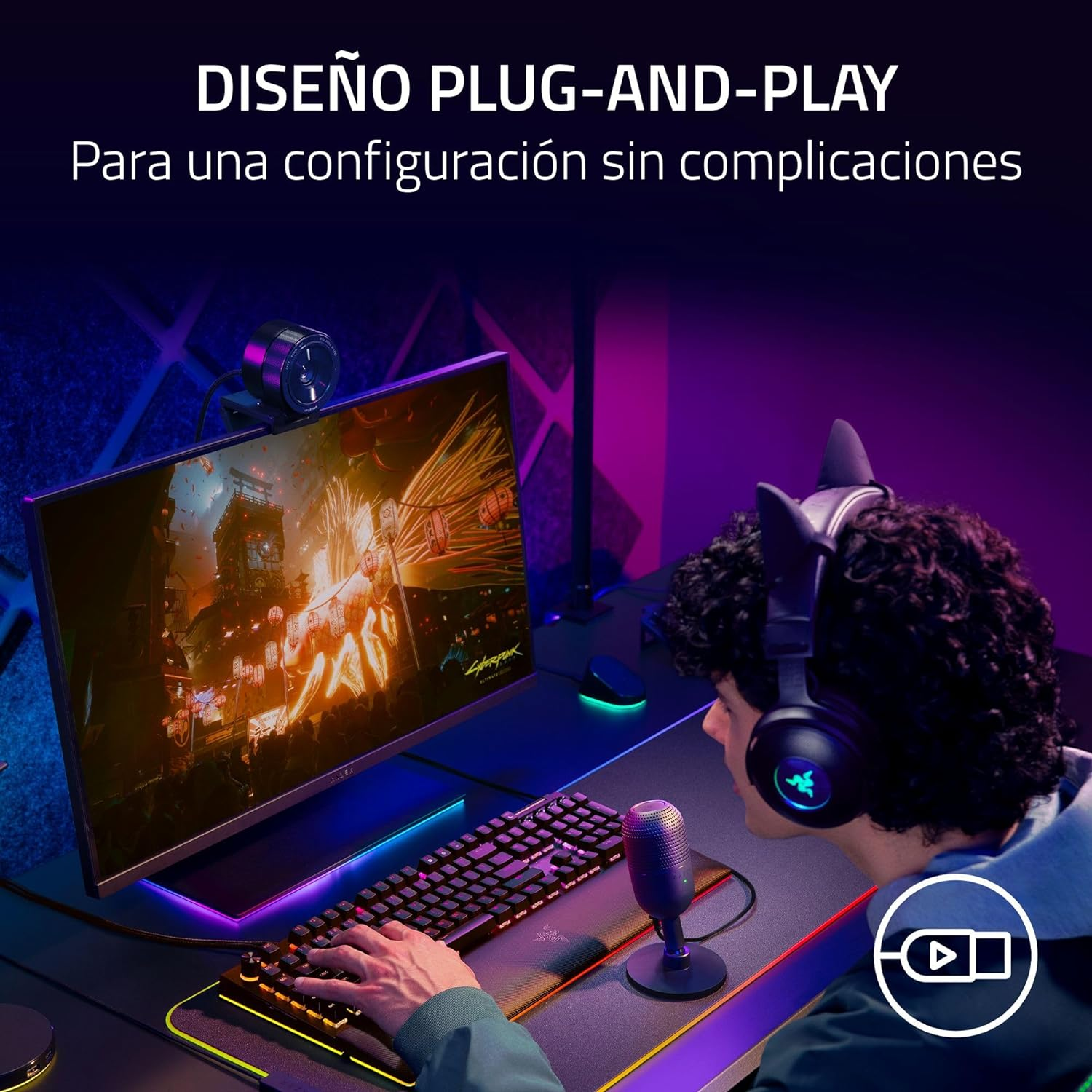 Jugador con auriculares, micrófono y teclado. Monitor muestra escena de juego.