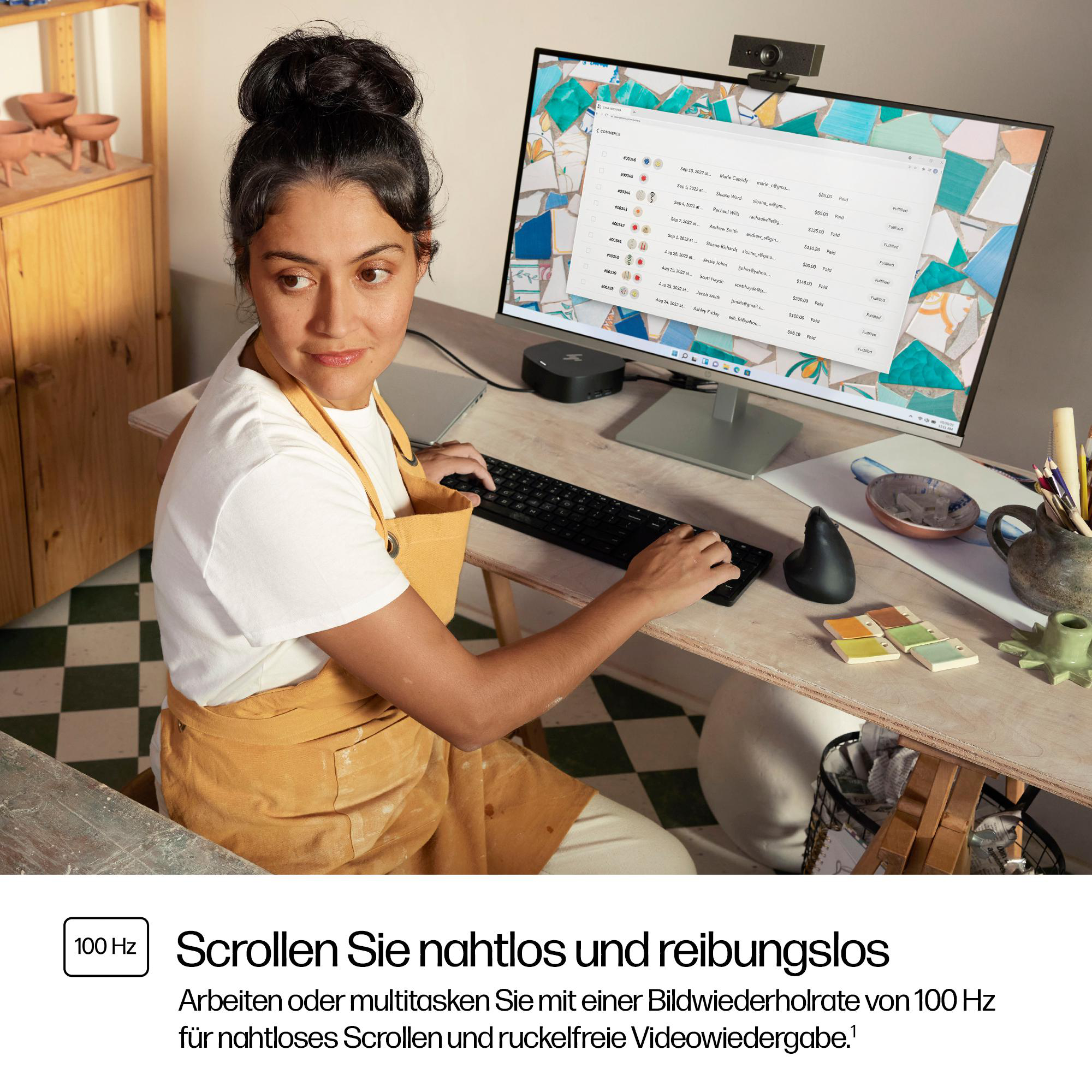 Frau arbeitet an Computer mit Monitor, Tastatur und Maus.