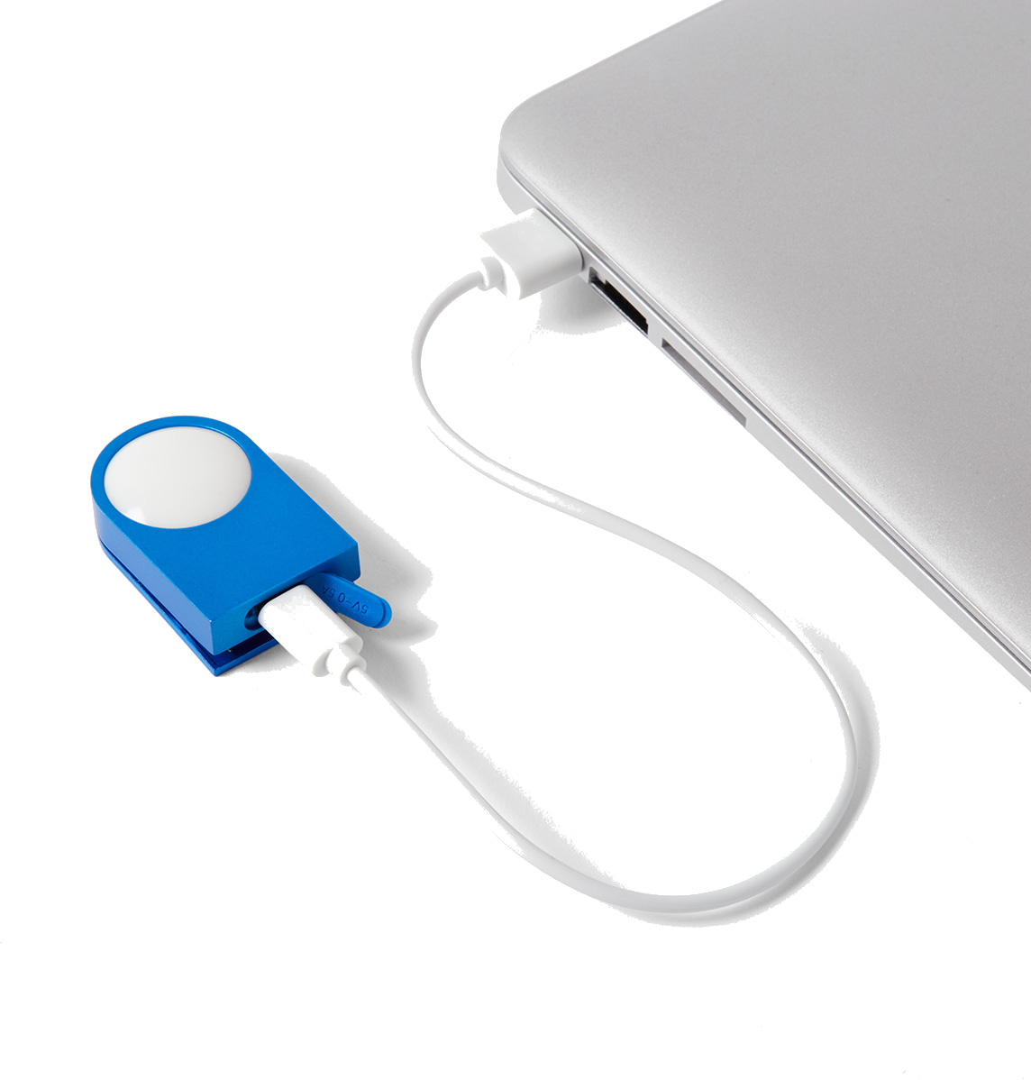 Niebieskie urządzenie z białym światłem jest połączone z laptopem za pomocą białego kabla. Laptop jest srebrny.