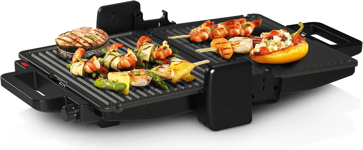 Egy elektromos grill különféle grillezett ételekkel, beleértve a garnélarákot, zöldségeket és húst.