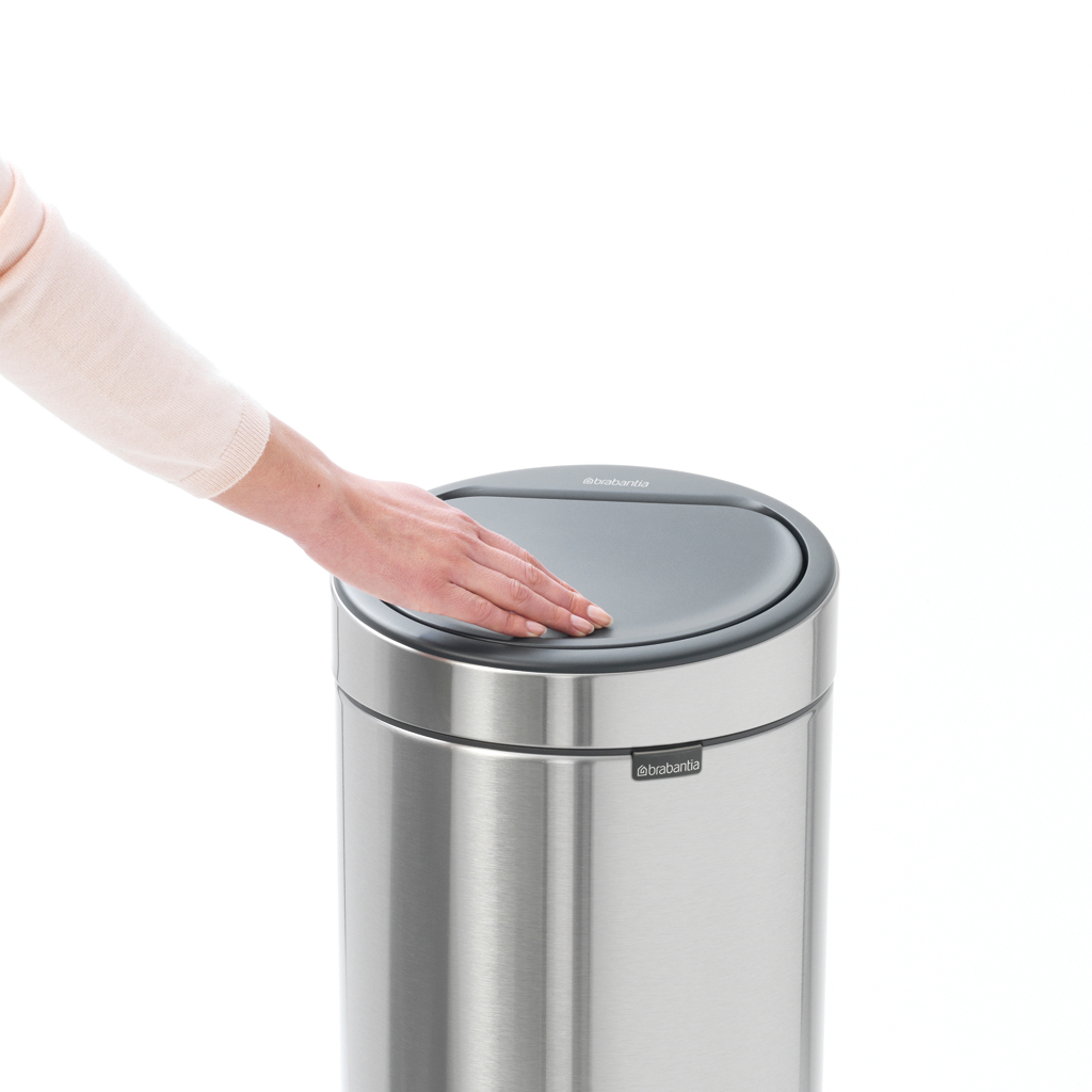 Eine Hand drückt auf den Deckel eines Brabantia-Mülleimers. Der Eimer ist aus Edelstahl.