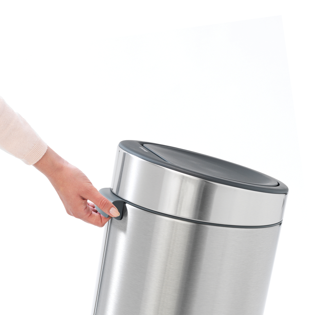 Hand öffnet einen Edelstahl-Mülleimer. Weißer Hintergrund.